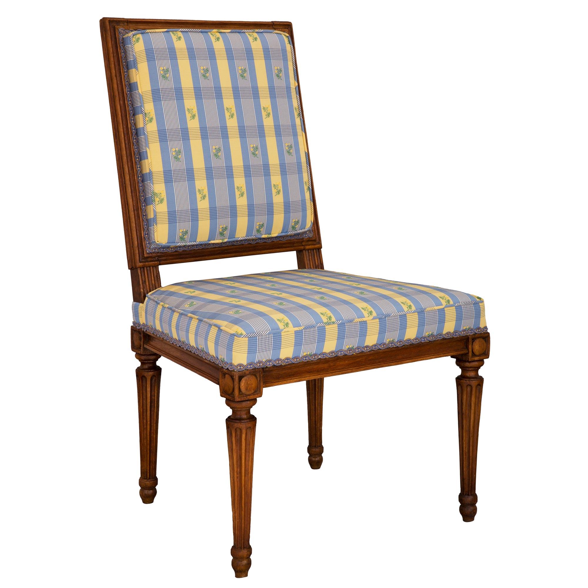 An elegant French 19th century Louis XVI st. Beechwood chair. The chair is raised by fine circular tapered fluted legs with lovely topie shaped feet. Above each leg are carved block reserves which center the straight apron with a fine mottled