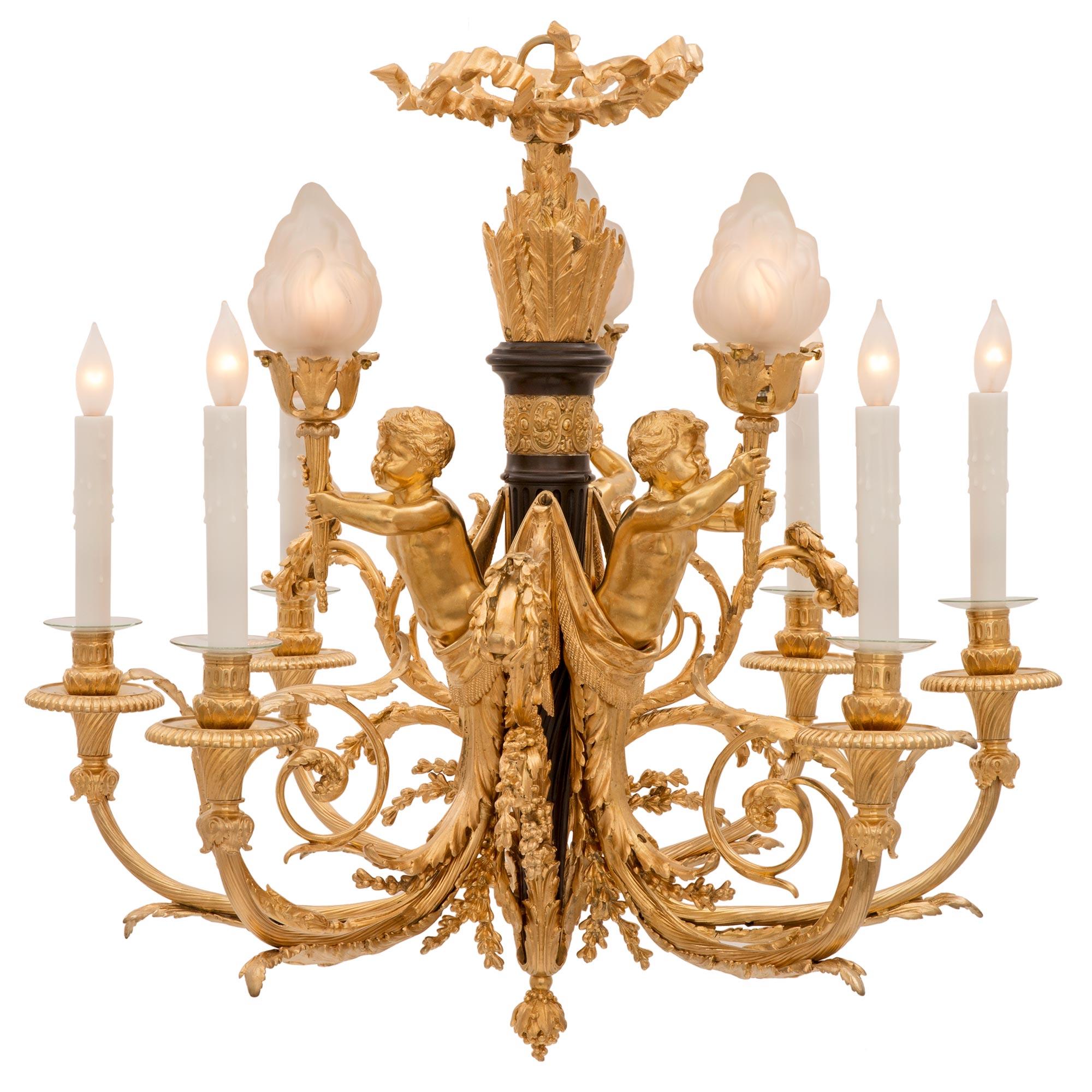 An exquisite French 19th century Louis XVI st. Belle Époque period ormolu, patinated bronze and frosted glass chandelier. The six arm, nine light chandelier is centered by a beautiful and finely detailed bottom acorn finial and a luxuriant array of