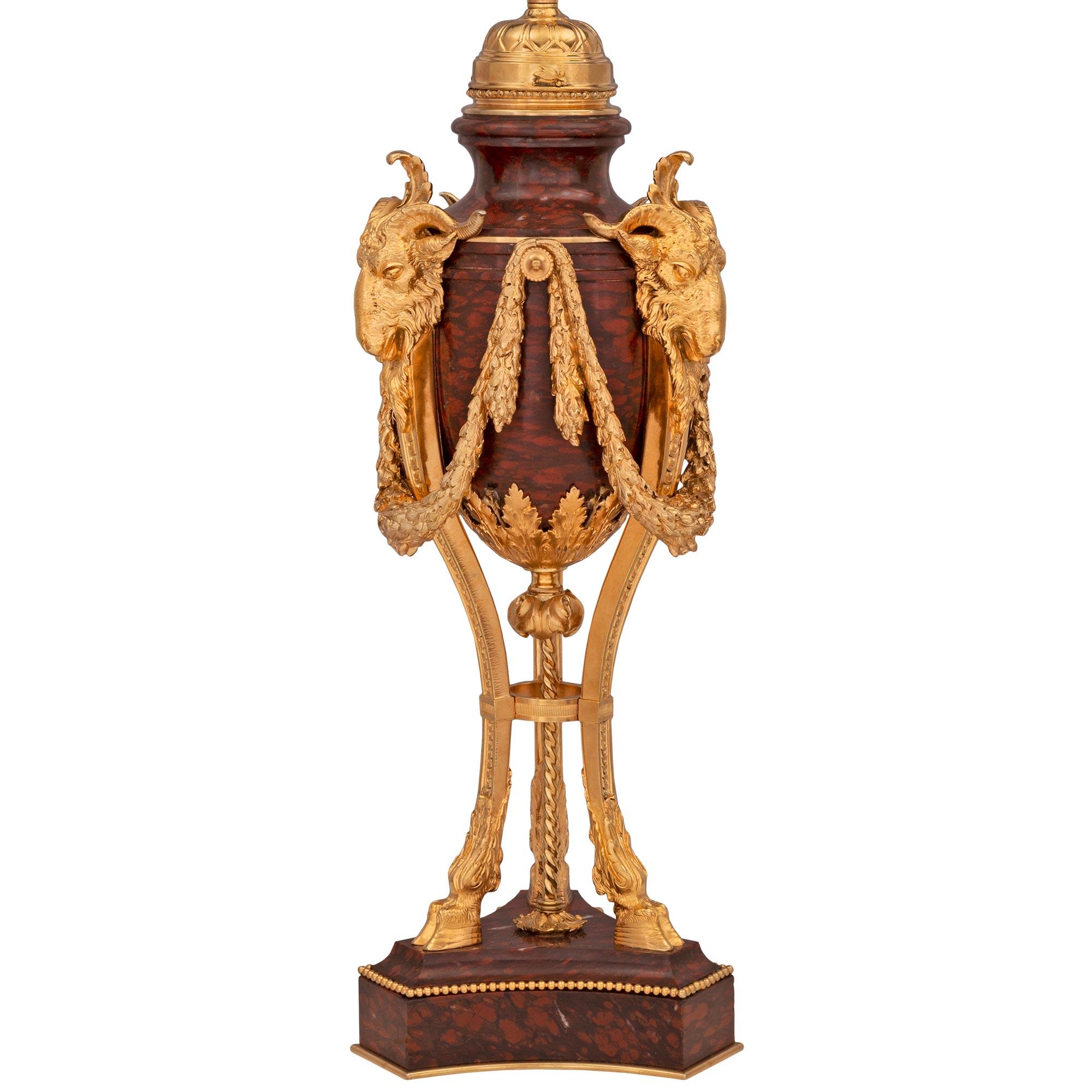 A stunning and extremely high quality French 19th century Louis XVI st. Belle Époque period ormolu and Rouge Griotte marble lamp. The elegant lamp is raised by a triangular Rouge Griotte marble base with fine concave sides and a mottled border. At