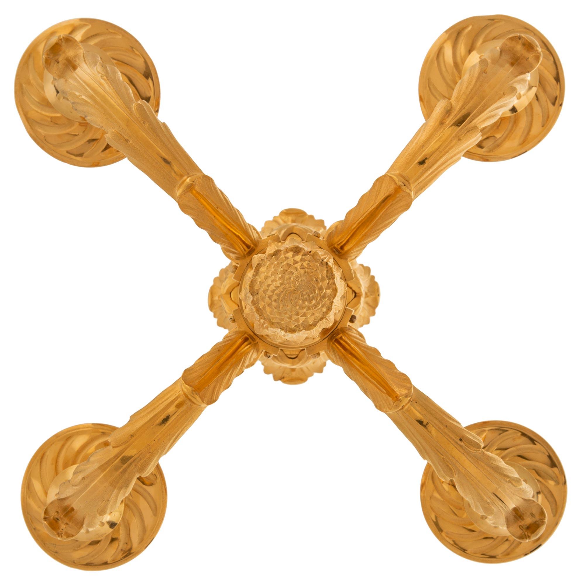 Un elegantissimo lampadario francese del XIX secolo in stile Belle Époque. Il lampadario a quattro bracci è centrato da un bellissimo finale a ghianda riccamente cesellato sotto raffinati disegni a palmetta che racchiudono l'impressionante fut