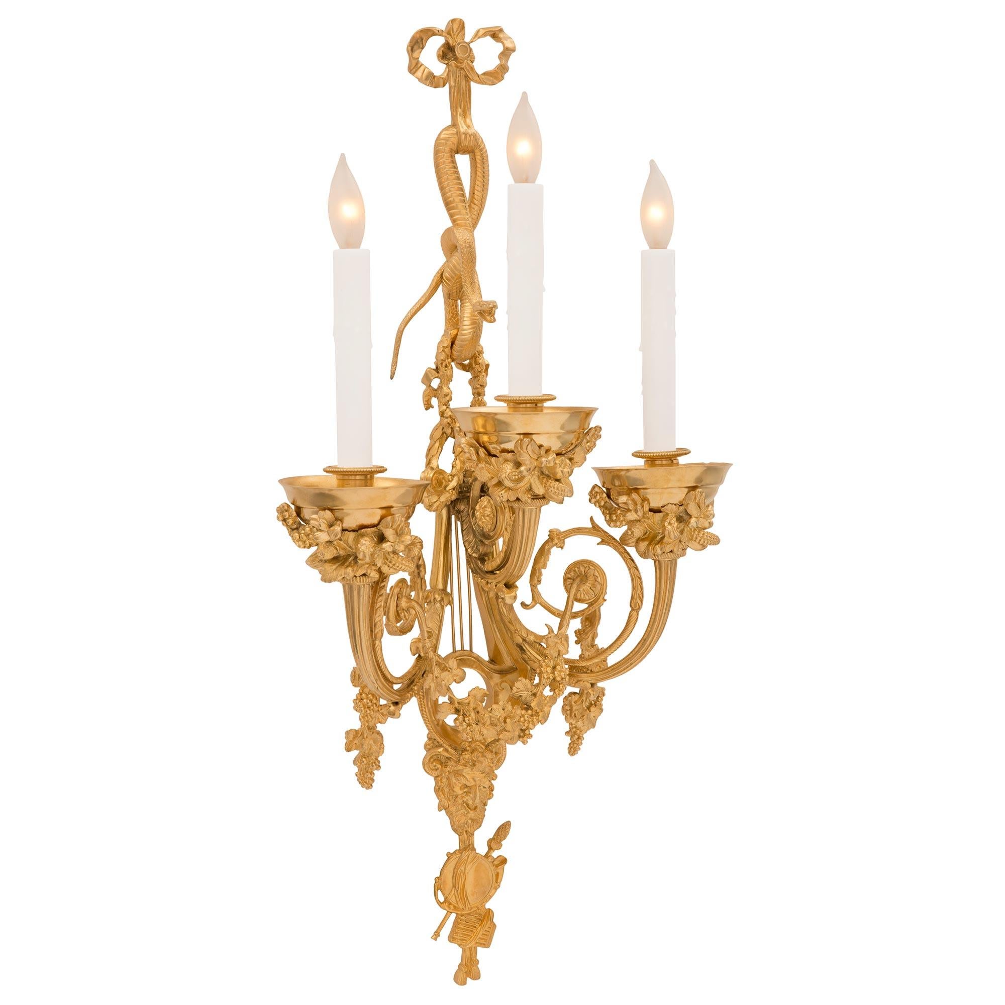 A stunning and very high quality French 19th century Louis XVI st. Belle Époque period ormolu sconces, signed Vian. Each sconce is centered by beautiful finely detailed musical instruments at the base with a tambourine, pan flute, French horn, and