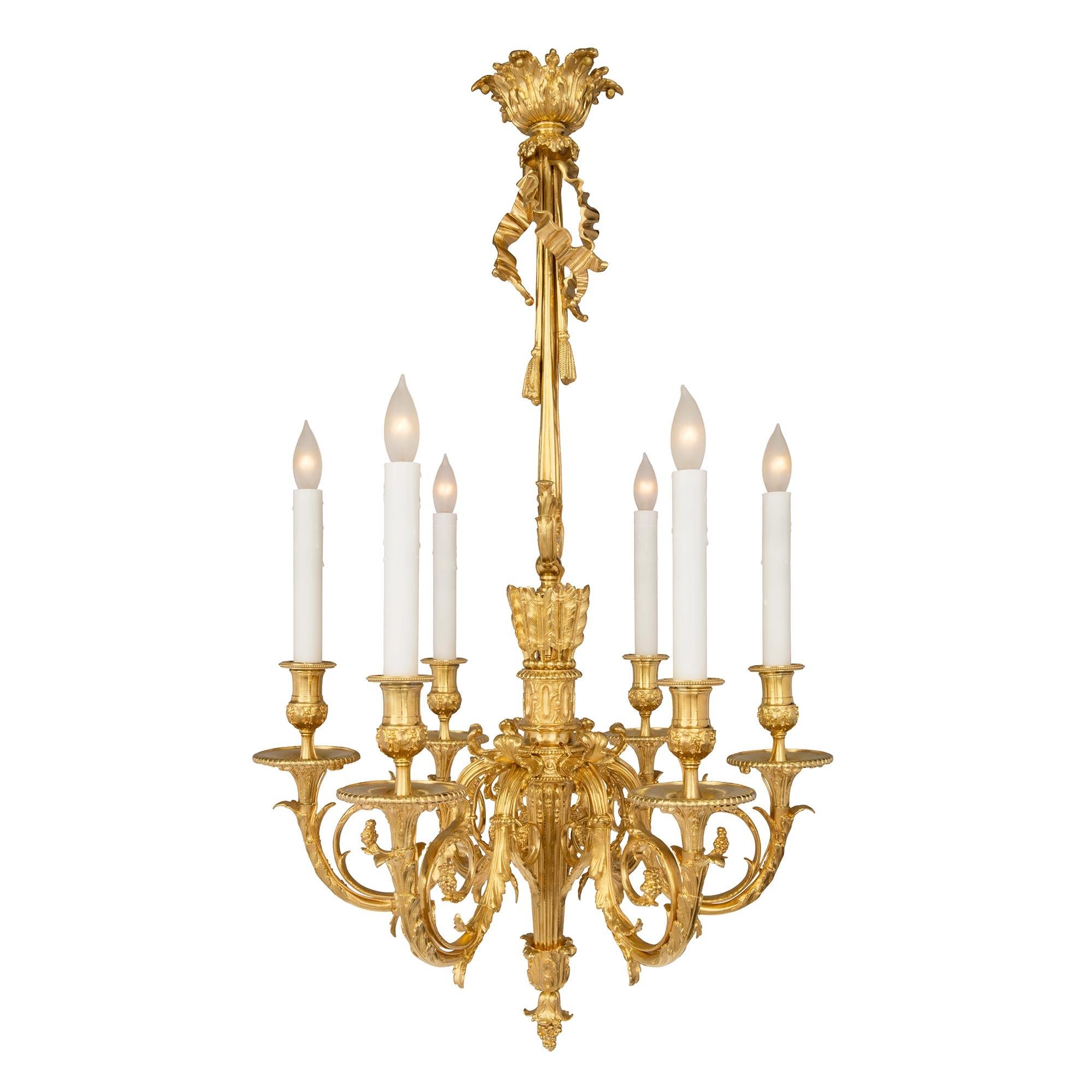 An extremely elegant and high quality French 19th century Louis XVI st. Belle Époque period six arm ormolu chandelier. The chandelier is centered by a charming and richly chased bottom acorn finial and large acanthus leaves. The striking fluted