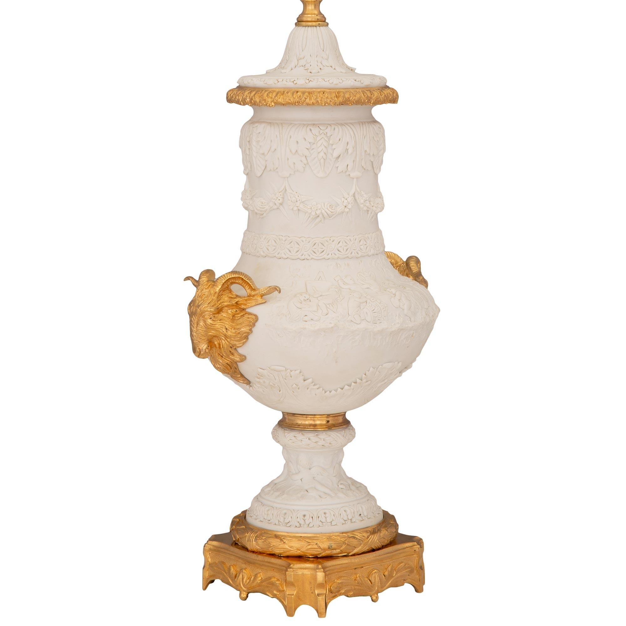 A stunning and extremely decorative French 19th century Louis XVI st. Biscuit de Sèvres porcelain and ormolu lamp. The lamp is raised by a beautiful square ormolu base with concave corners, charming foliate designs, and a finely detailed wrap around