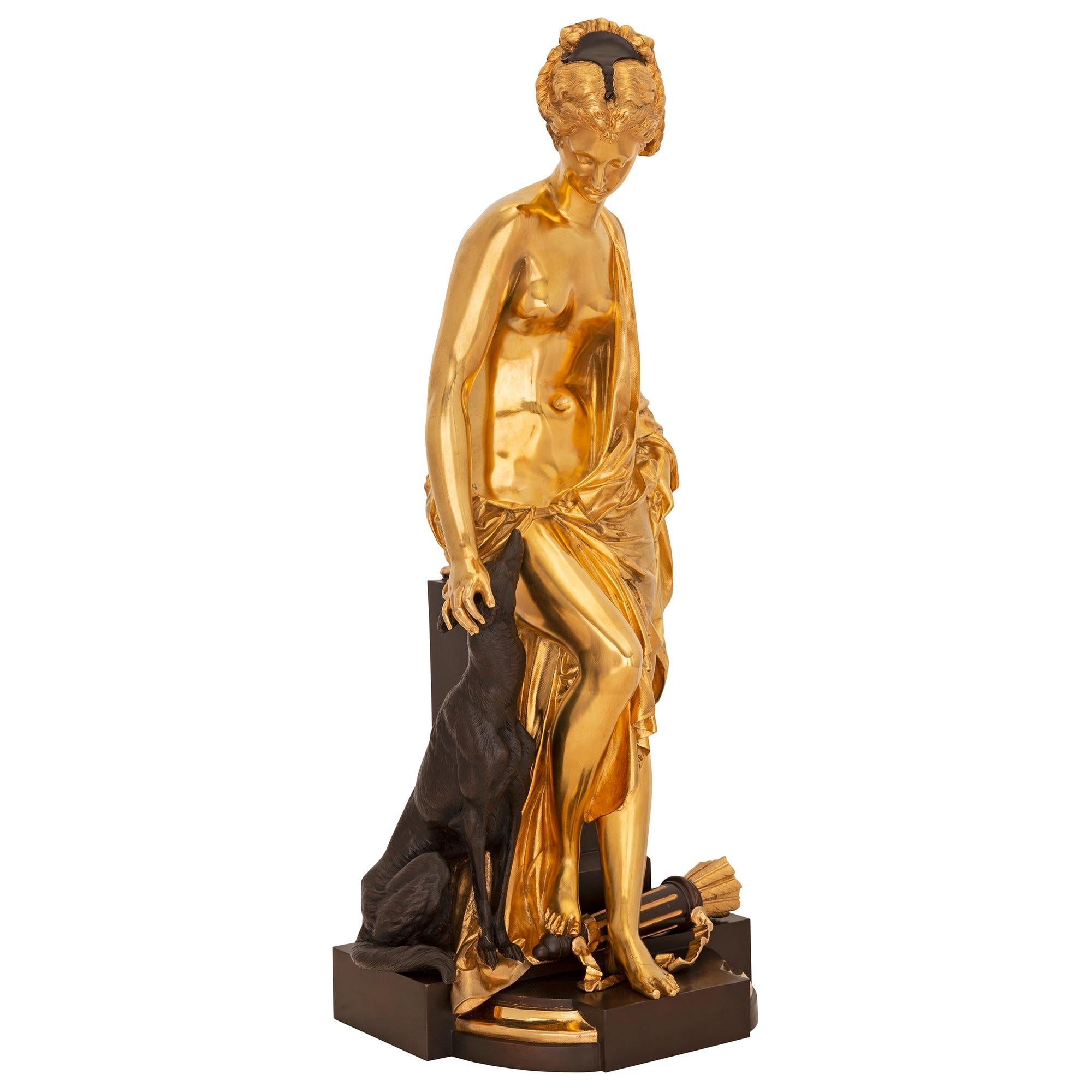 Une élégante statue de Diane et son chien en bronze patiné et bronze doré de style Louis XVI du XIXe siècle, signée A. Carrier. La statue est surmontée d'une base très décorative avec des motifs en bloc et une fine bordure tachetée. Au centre, la