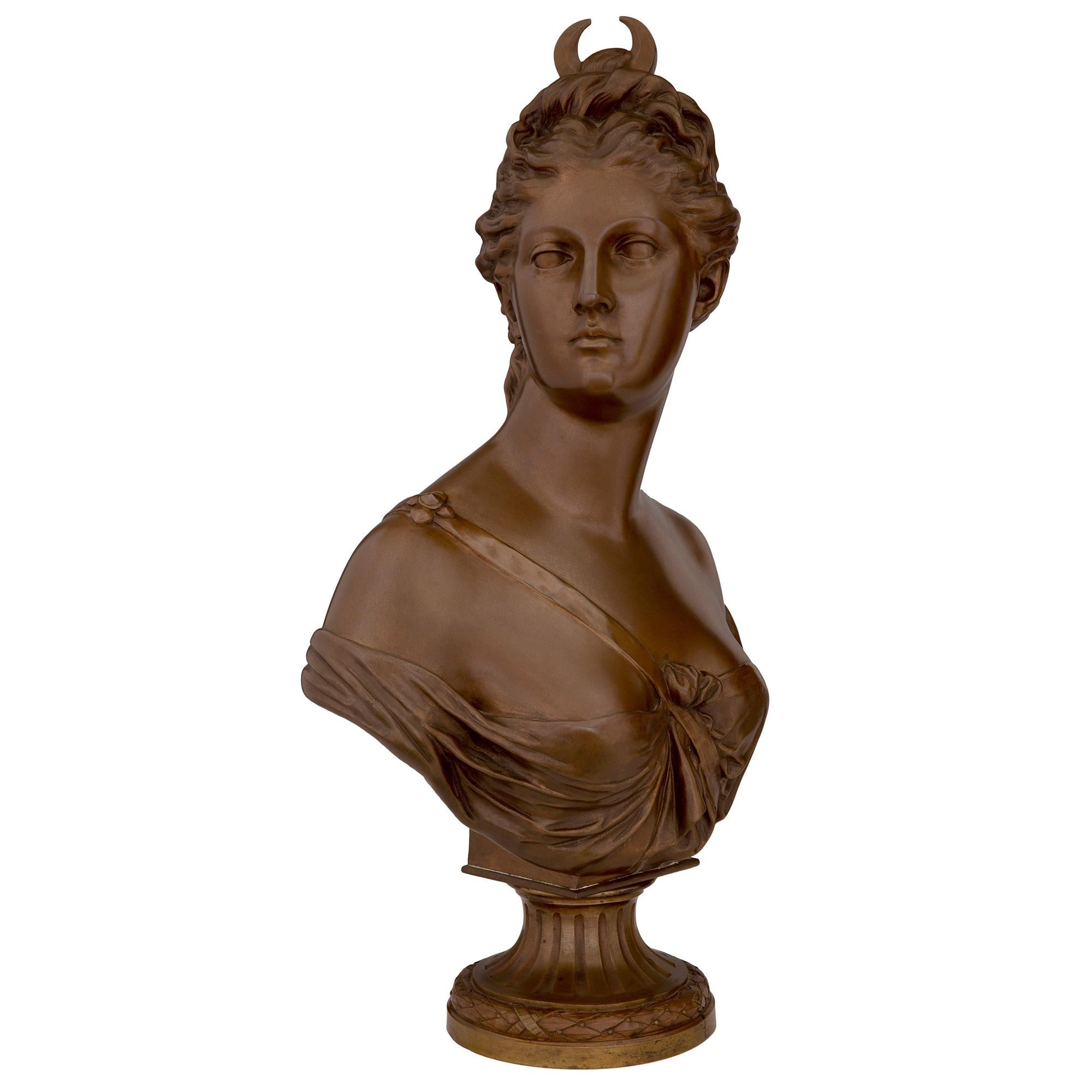 Superbe buste de Diane chasseresse en bronze patiné de style Louis XVI, signé HOUDON et SUSSE Frères, datant du milieu du XIXe siècle. Le buste est surmonté d'une base circulaire dotée d'un fin bandeau de laurier enrubanné et d'un socle cannelé.