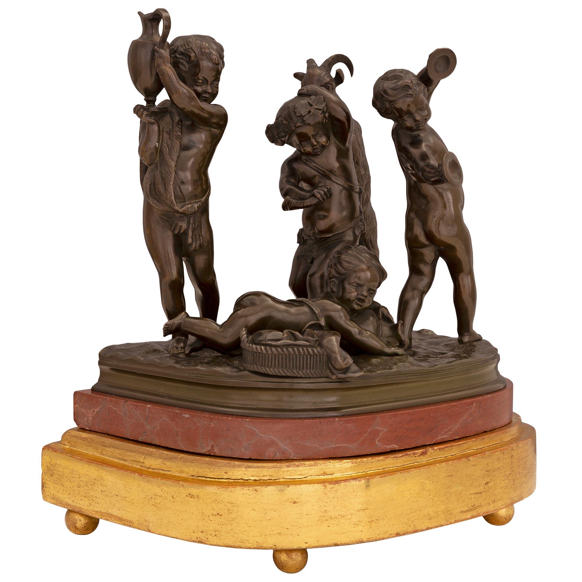 Eine hochwertige und sehr charmante französische Statue aus dem 19. Jahrhundert aus patinierter Bronze, Vergoldung und Marmor Rouge du Languedoc. Die Statue steht auf einem eleganten Sockel aus vergoldetem Holz mit feinen Kugelfüßen und einem