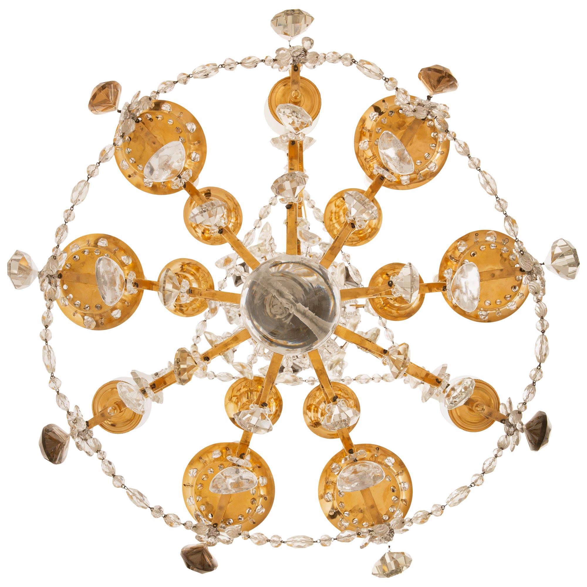 A stunning and most unique French late 19th century Louis XVI st. Ormolu, Silvered Bronze and Crystal chandelier, possibly by Maison Bagues. The nine arm, thirty light chandelier is centered at the bottom by an elegant solid smooth Crystal ball
