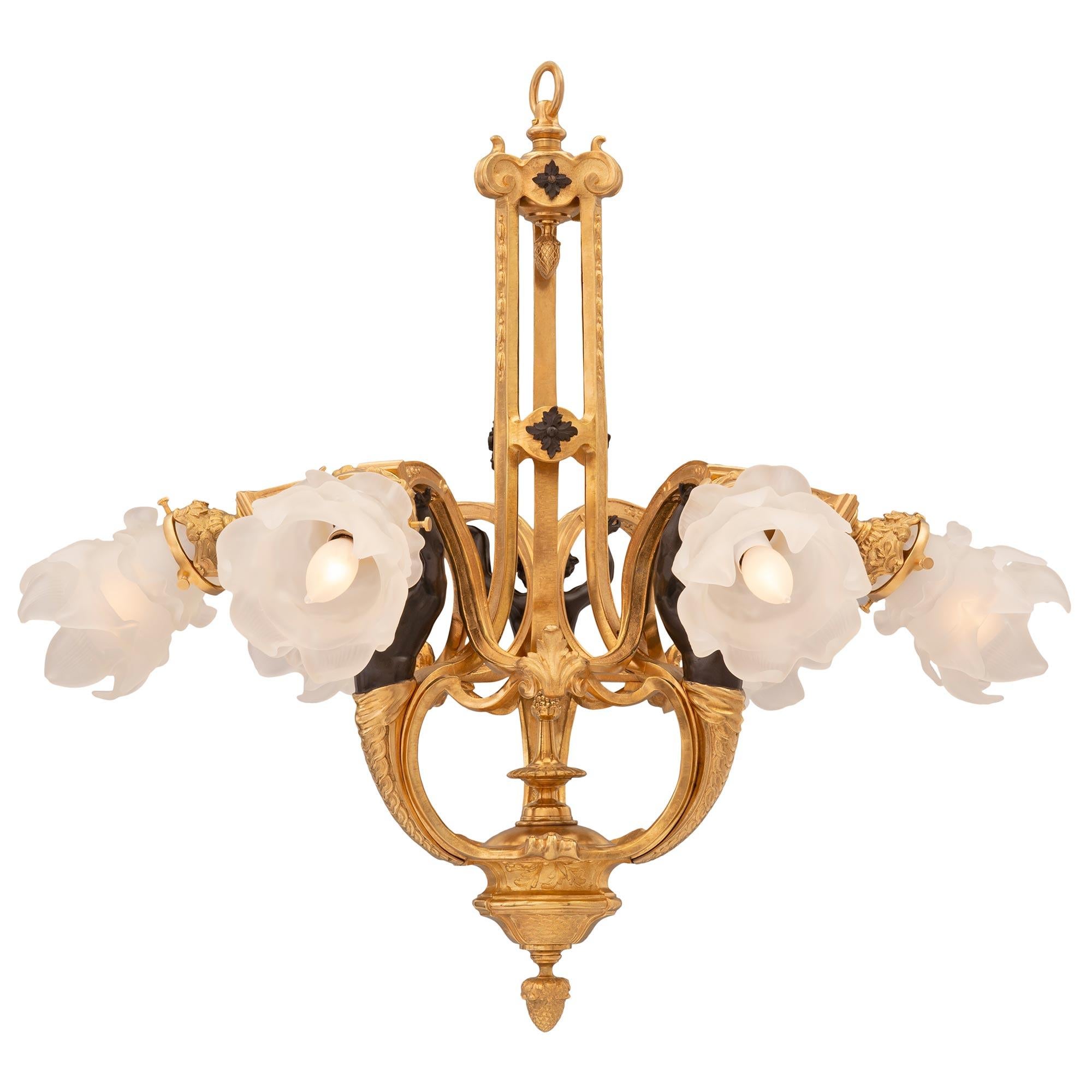 A beautiful and unique French 19th century Louis XVI st. patinated bronze, ormolu, and frosted glass chandelier. The six arm chandelier is centered by a fine bottom acorn finial below lovely fish scale designs leading up to three most decorative