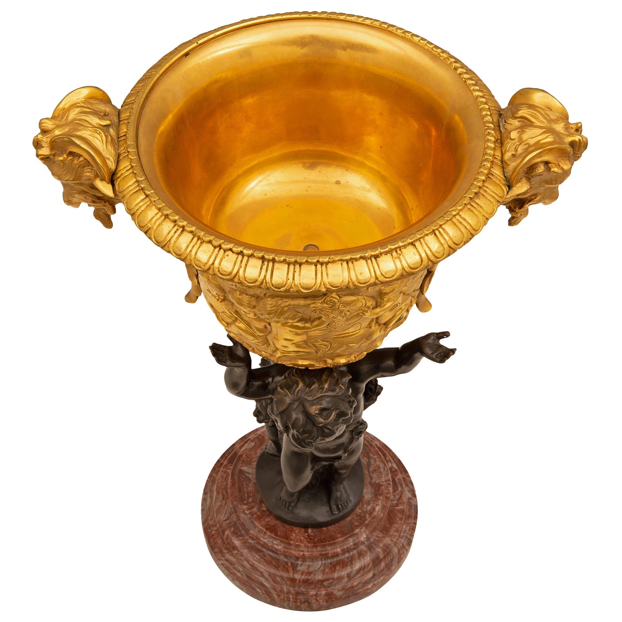 A remarkable and most charming French 19th century Louis XVI st. ormolu, patinated bronze, and Rose Vif des Pyrénées marble centerpiece. The centerpiece is raised by an elegant circular Rose Vif des Pyrénées marble base with a fine stepped mottled