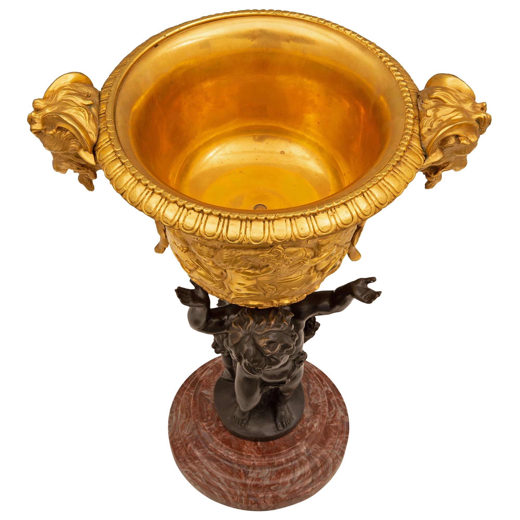 Remarquable et charmant centre de table en bronze doré, bronze patiné et marbre Rose Vif des Pyrénées de style Louis XVI du XIXe siècle. La pièce centrale est surélevée par une élégante base circulaire en marbre Rose Vif des Pyrénées avec une fine