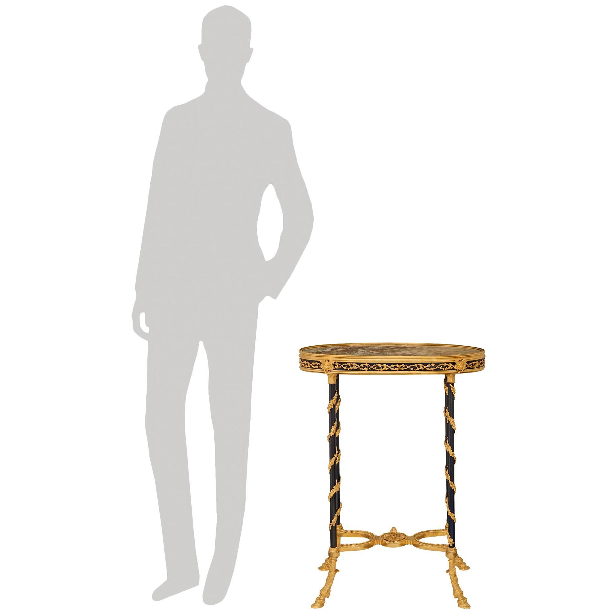 Table d'appoint ovale en bronze émaillé, bronze doré et marbre, de grande qualité et de style Louis XVI du XIXe siècle. Cette superbe table repose sur de minces pieds en bronze émaillé bleu cobalt, ornés de guirlandes de feuillage en spirale en