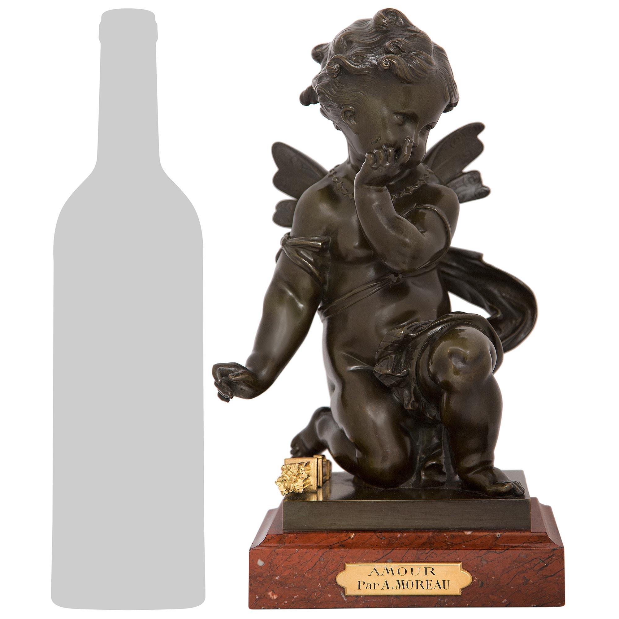 An engaging and high-quality French 19th century Louis XVI st. patinated Bronze, Ormolu and Rouge Griotte marble statue titled Amour, by Auguste Moreau. This charming Bronze is raised by a square Rouge Griotte marble base with a mottled border and