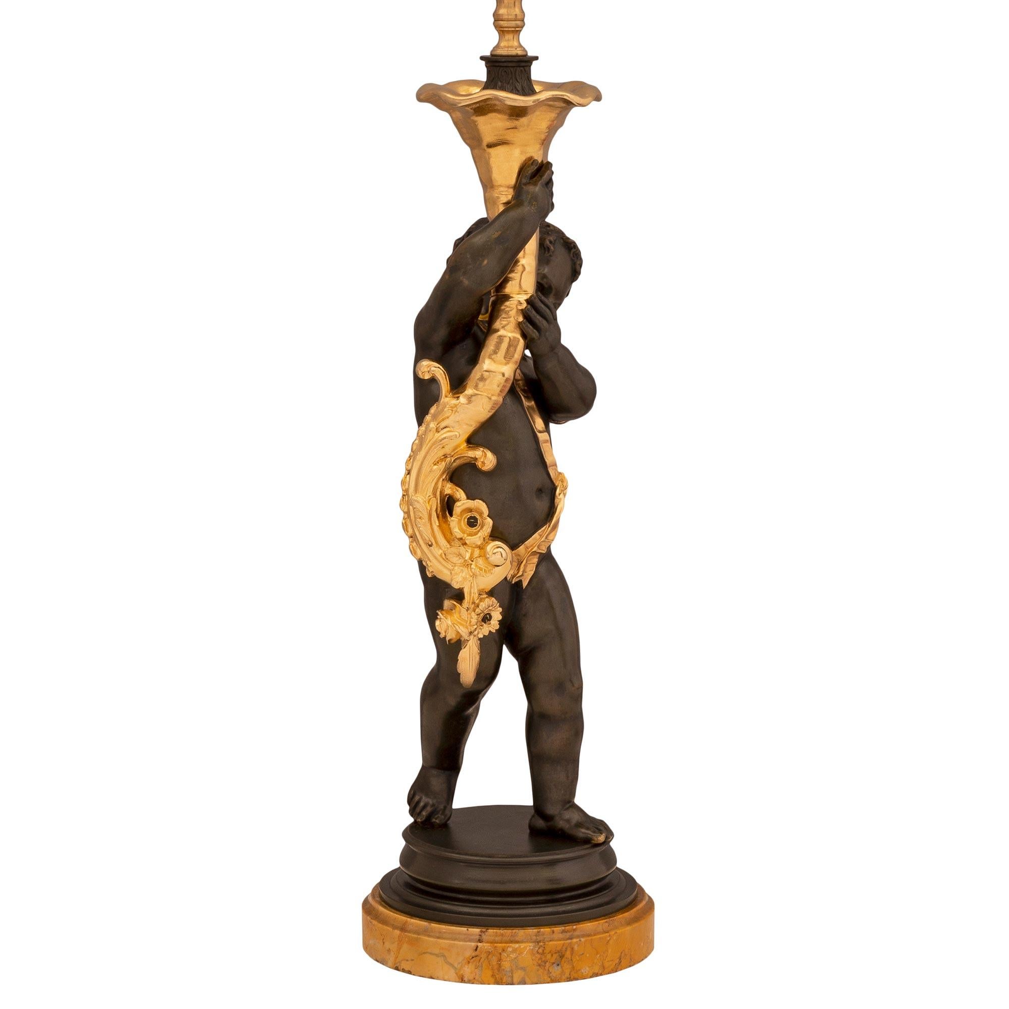 A charming and very high quality French 19th century Louis XVI st. Belle Époque period patinated bronze, ormolu and Sienna marble lamp. The charming lamp is raised by a fine circular Sienna marble base with a lovely mottled border. The charming