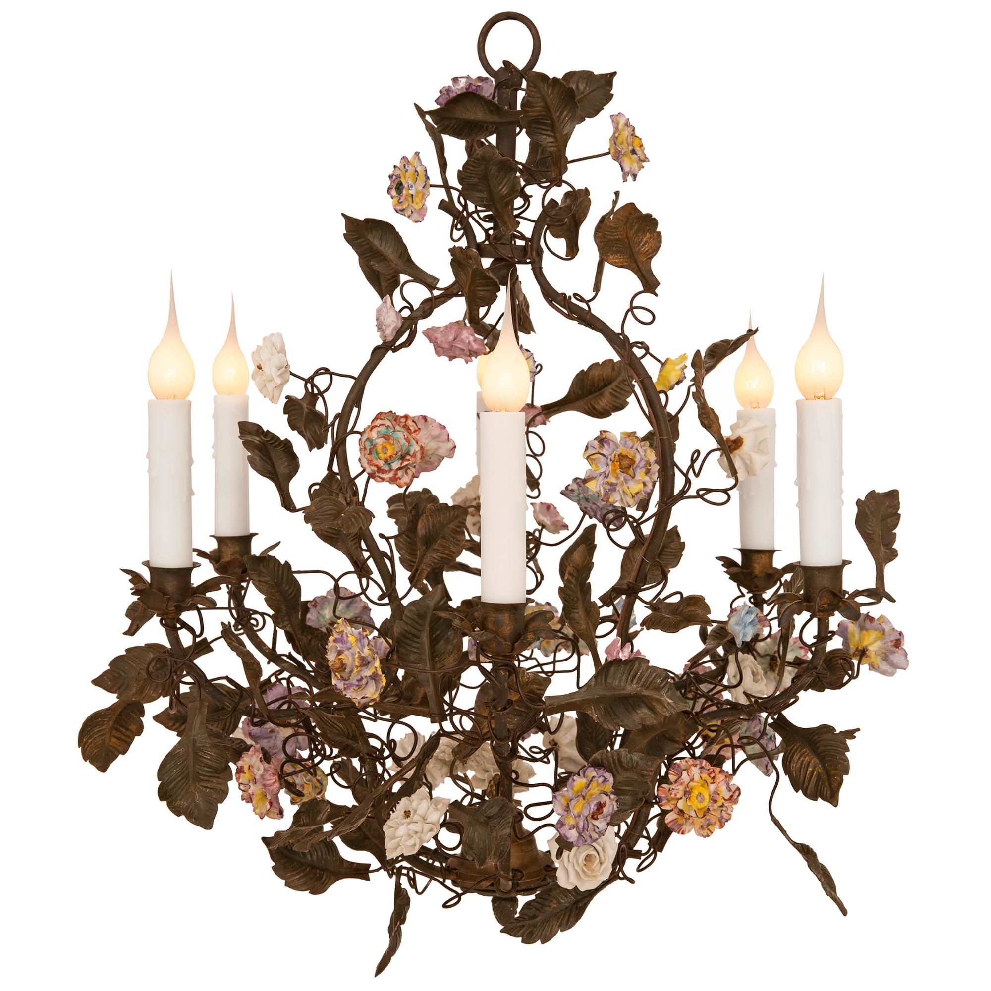 A charming and most decorative French 19th century Louis XVI st. patinated bronze, pressed metal and Saxe porcelain chandelier. The six arm chandelier is centered by a lovely floral bottom finial from where the branch designed arms lead upwards.