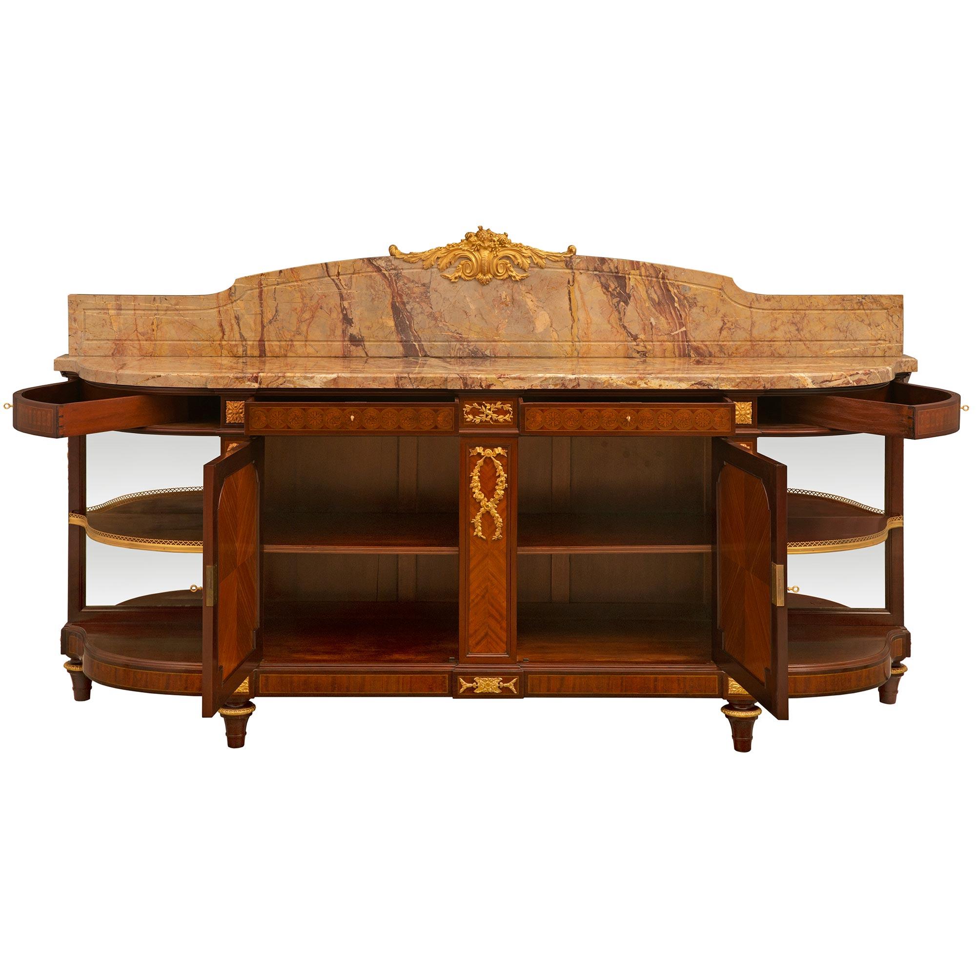 An impressive and most elegant French 19th century Louis XVI st. Mahogany, Tulipwood, Kingwood, Ormolu and marble buffet, signed Maison Forest. The buffet is raised on solid Mahogany topie shaped feet with an Ormolu top band with an egg and dart