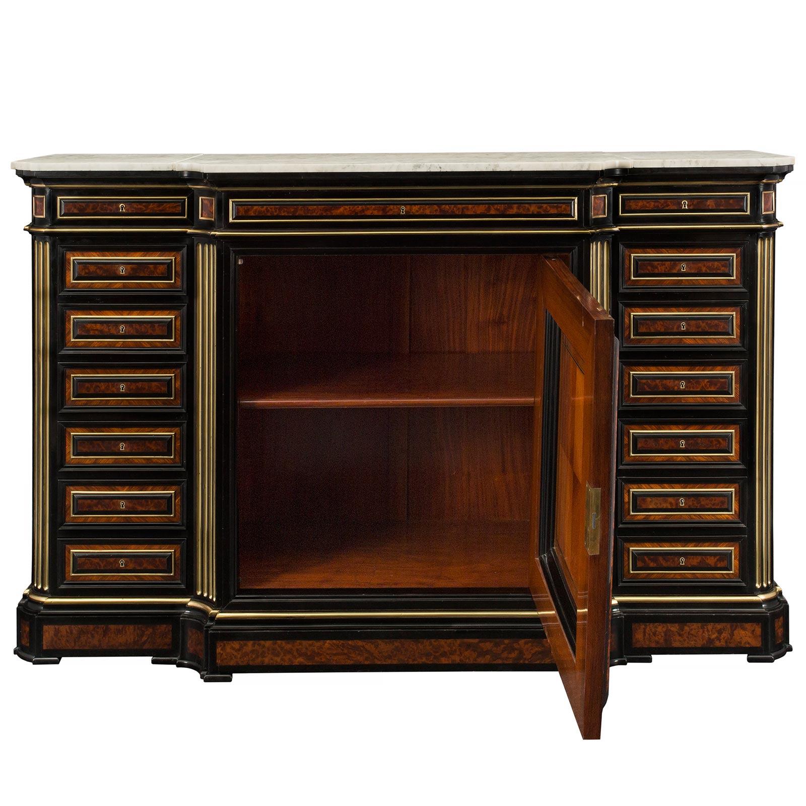 A spectacular and most impressive French 19th century Louis XVI st. burl walnut and ormolu cabinet by Guillaume Grohé. The cabinet is raised by ebony block supports below the frieze with a protruding central section. The cabinet door is elaborately