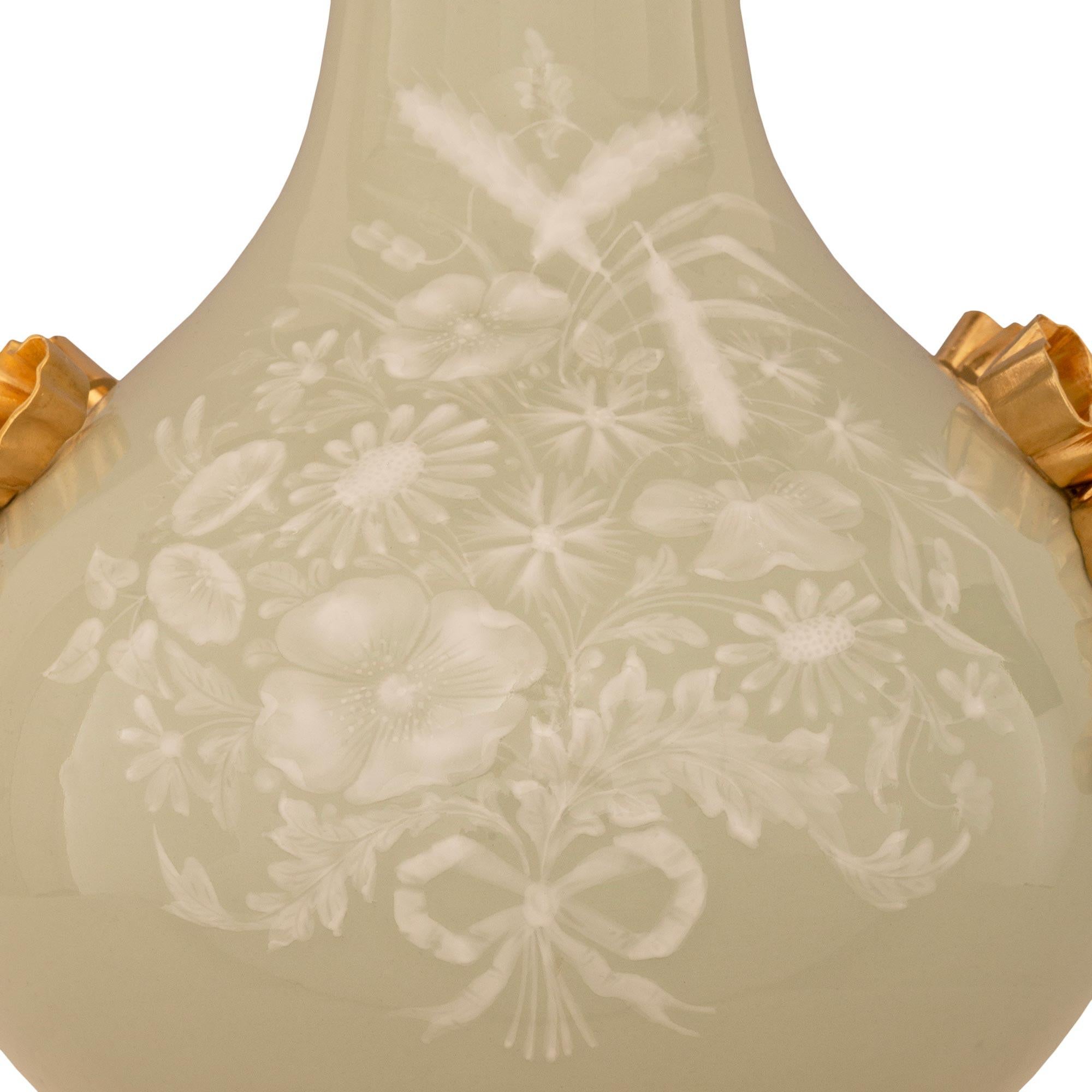A lovely and most decorative French 19th century Louis XVI st. Celadon Porcelain and Ormolu lamp. This stunning Pâte-Sur-Pâte Porcelain lamp is raised by an elegant Ormolu base supported by four circular tapered fluted feet with a beaded band around