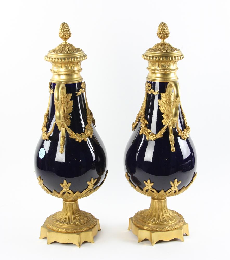 French 19th century Louis XVI style cobalt blue porcelain and ormolu urns with swan handles 
Beautiful gilt decoration with garlands, flowers, and foliate designs. Acorn decorated lids with acanthus leaf designs.