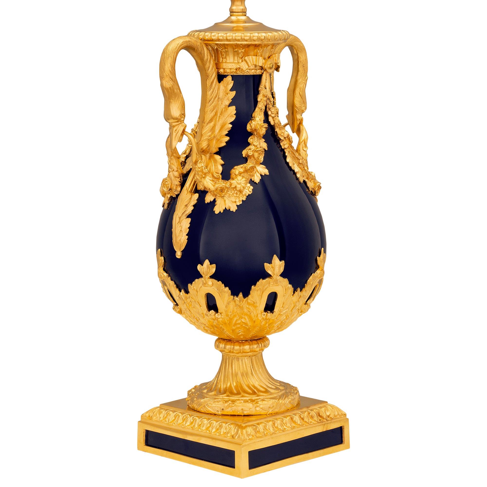 A striking and very high quality French 19th century Louis XVI st. cobalt blue Sèvres porcelain and ormolu lamp. The lamp is raised by a square ormolu base with elegant and unique fitted porcelain plaques at each side with a wrap around Coeur de Rai