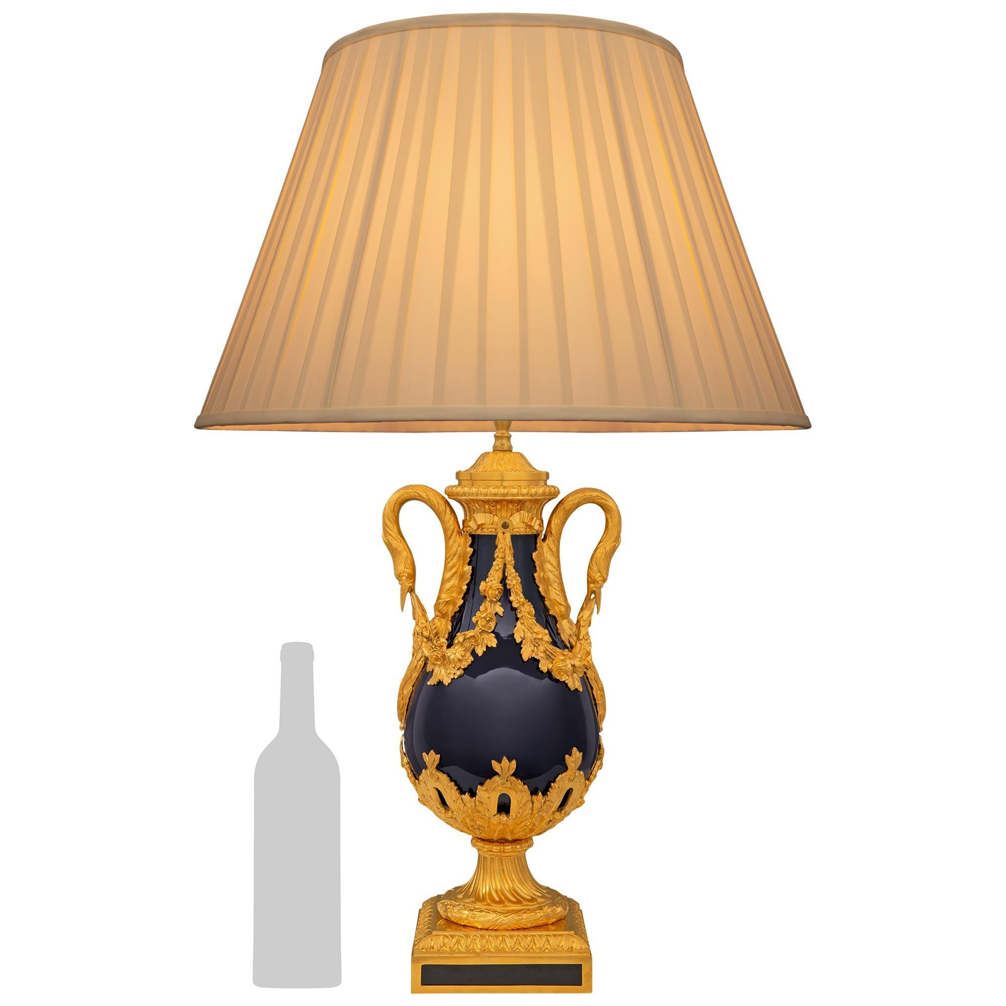 A striking and very high quality French 19th century Louis XVI st. cobalt blue Sèvres porcelain and Ormolu lamp. The lamp is raised by a square Ormolu base with elegant and unique fitted porcelain plaques at each side with a wrap around Coeur de Rai