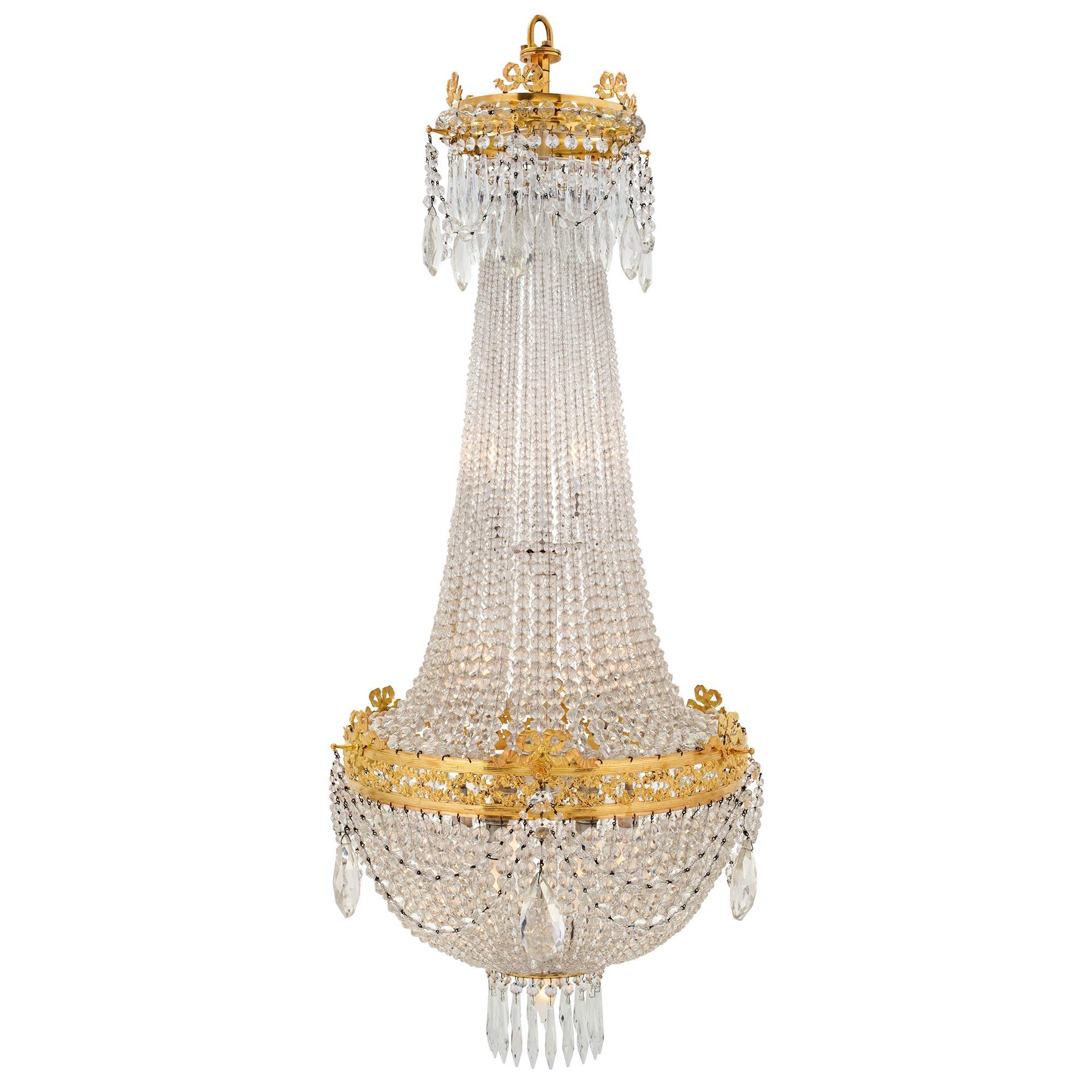 A very elegant French 19th century Louis XVI st. crystal and ormolu chandelier. This Mongolfière, air balloon, designed chandelier has a circular base with hanging pendants. Crystal garlands join to the central pierced ormolu band with foliate