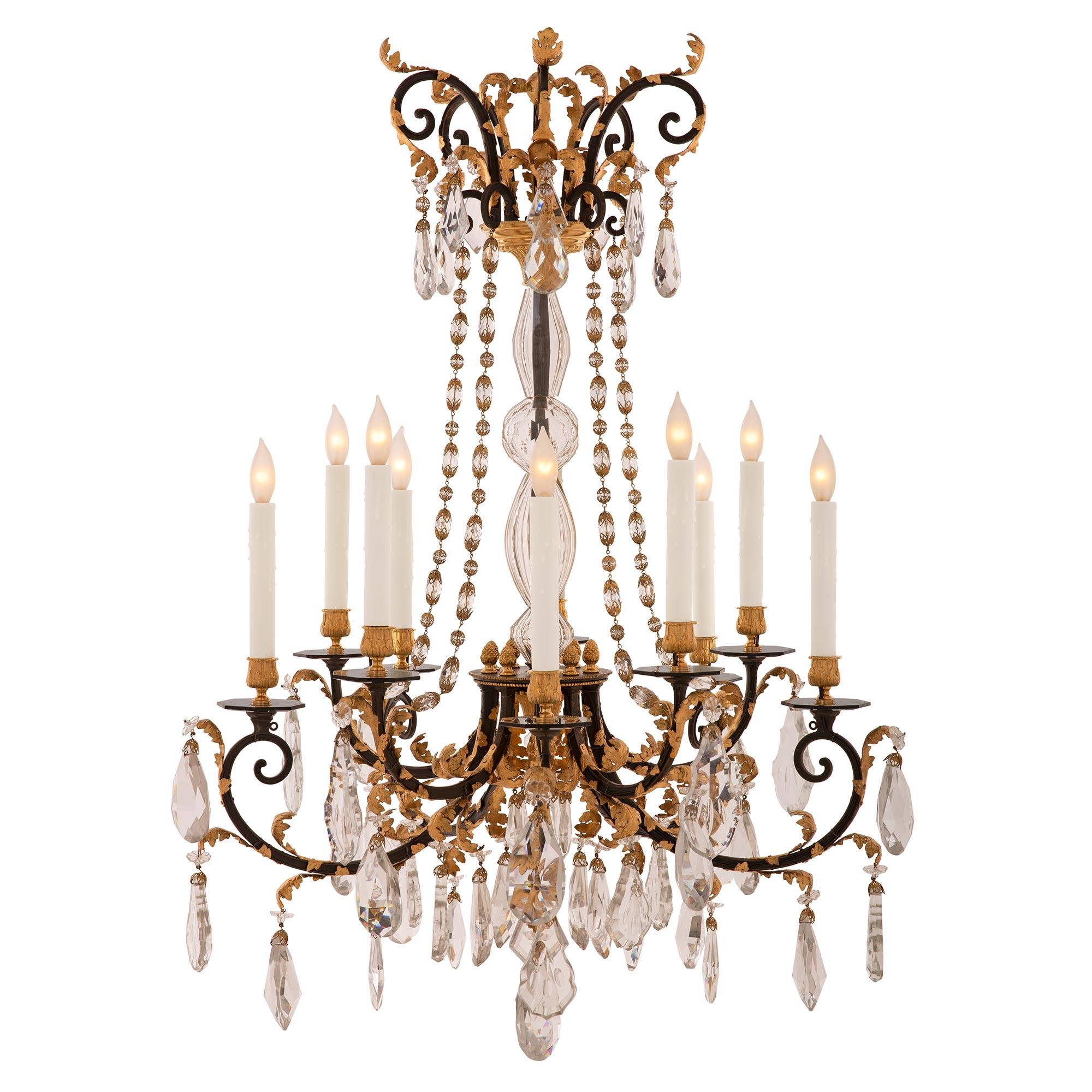A stunning and very unique French 19th century Louis XVI st. wrought iron, gilt metal, ormolu, and crystal chandelier. The ten arm chandelier is centered by an exceptional and most decorative array of cut and etched crystal pendants below the