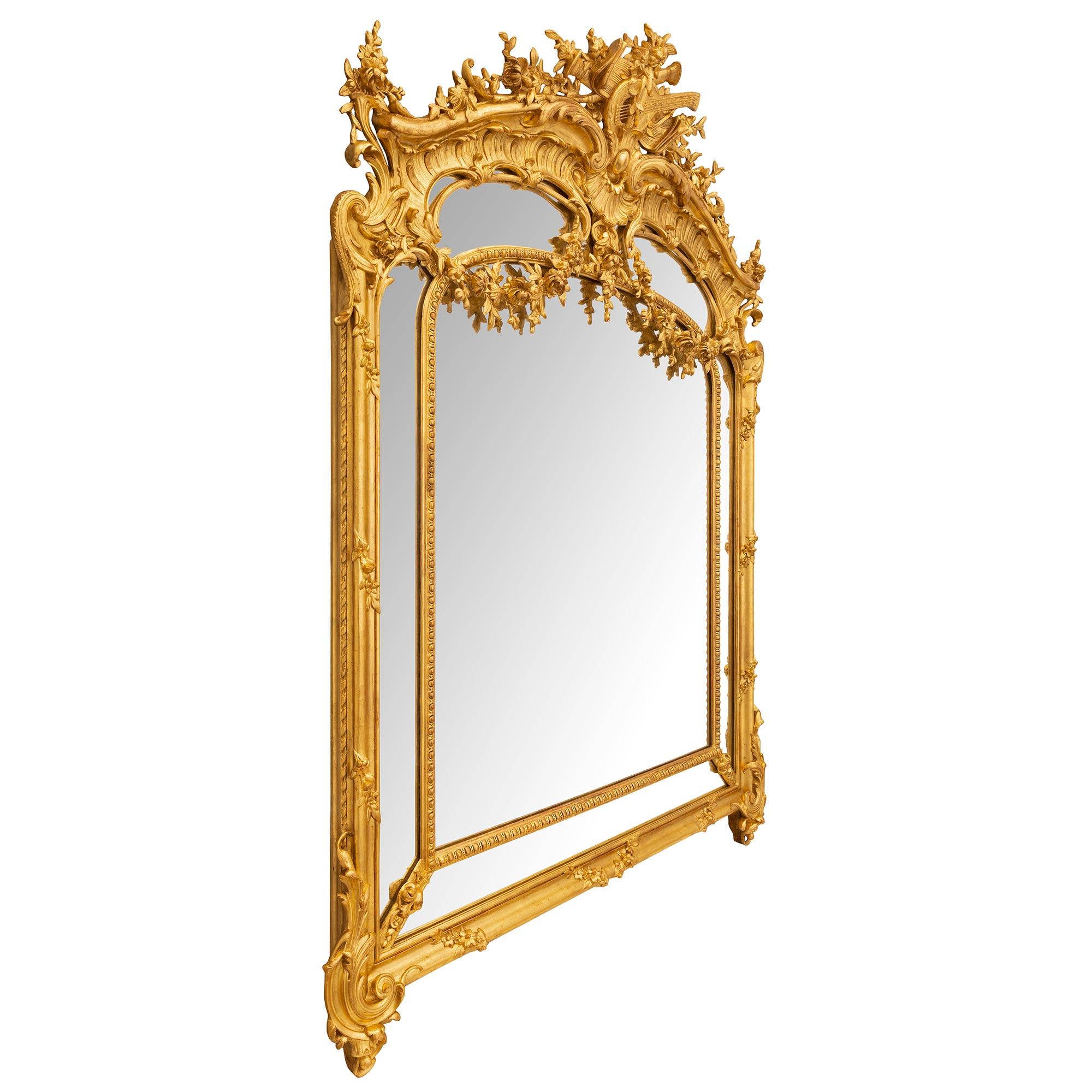 Exceptionnel miroir en bois doré à double encadrement de style Louis XVI du XIXe siècle. Le miroir a conservé toutes ses plaques de miroir d'origine et le miroir central est encadré par un magnifique et très décoratif bandeau enveloppant conçu par