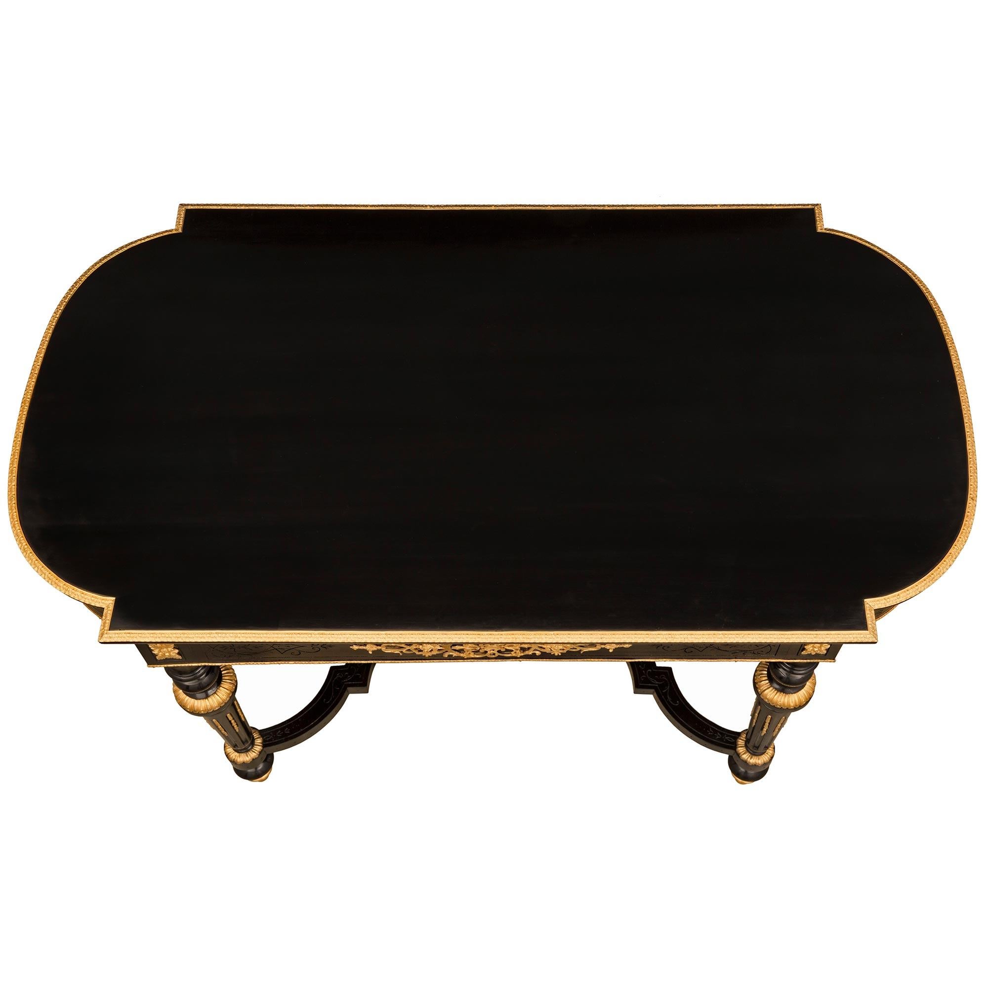 An impressive French 19th century Louis XVI st. Napoleon III period ebony and ormolu center table. The table is raised by exceptional and most elegant topie shaped ormolu feet below the circular tapered fluted legs with Fine fitted foliate