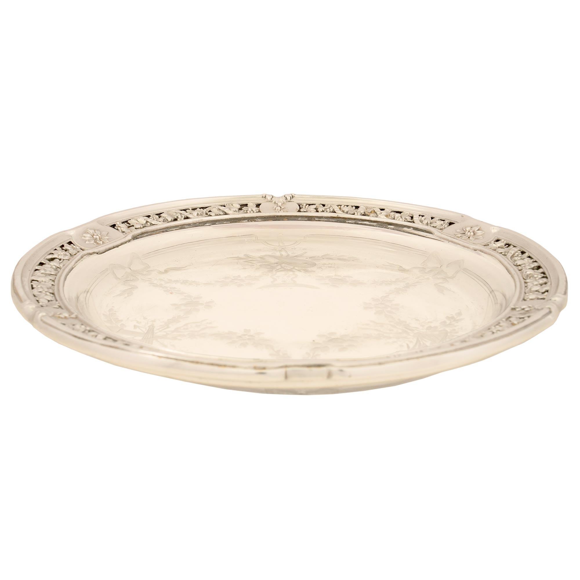 An elegant French 19th century Louis XVI st. etched crystal and silver plated decorative plate. The central dish is a lovely etched crystal with foliate and gardening designs. The crystal plate is framed within a pierced silver plated moulded border