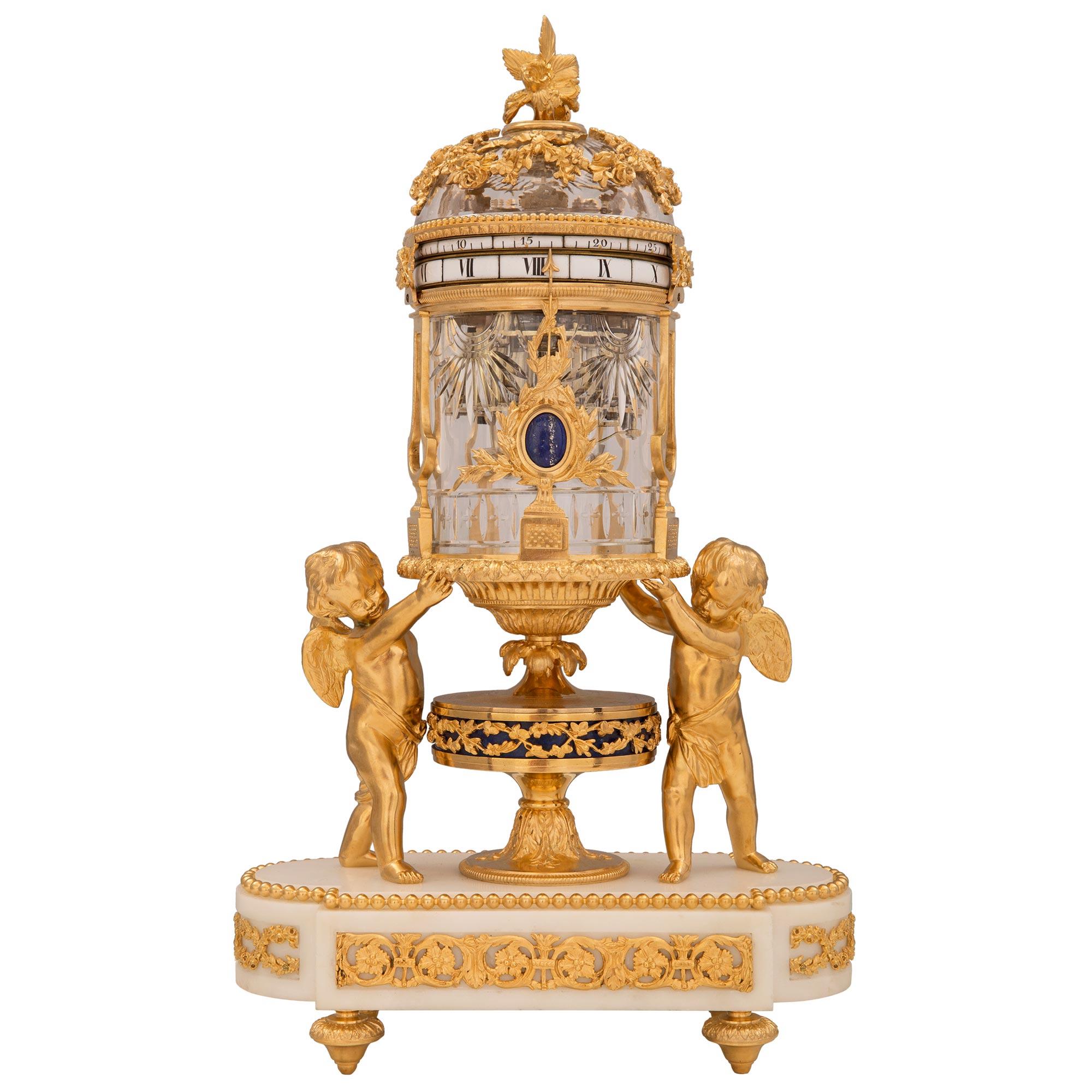 A stunning and extremely high quality French 19th century Louis XVI st. Belle Époque period ormolu, white Carrara marble, Lapis Lazuli, and Baccarat crystal garniture set retailed by Tiffany & Co. The central striking annular clock is raised by