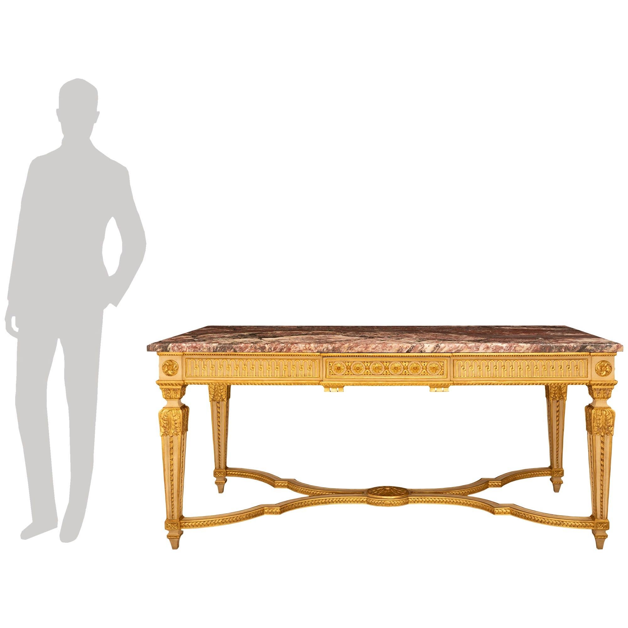 Atractiva y elegantísima mesa central francesa de finales del siglo XIX, de estilo Luis XVI, patinada, de madera dorada y mármol Breche Rouge. Esta impresionante consola rectangular de un solo cajón se eleva sobre cuatro patas cuadradas cónicas y se