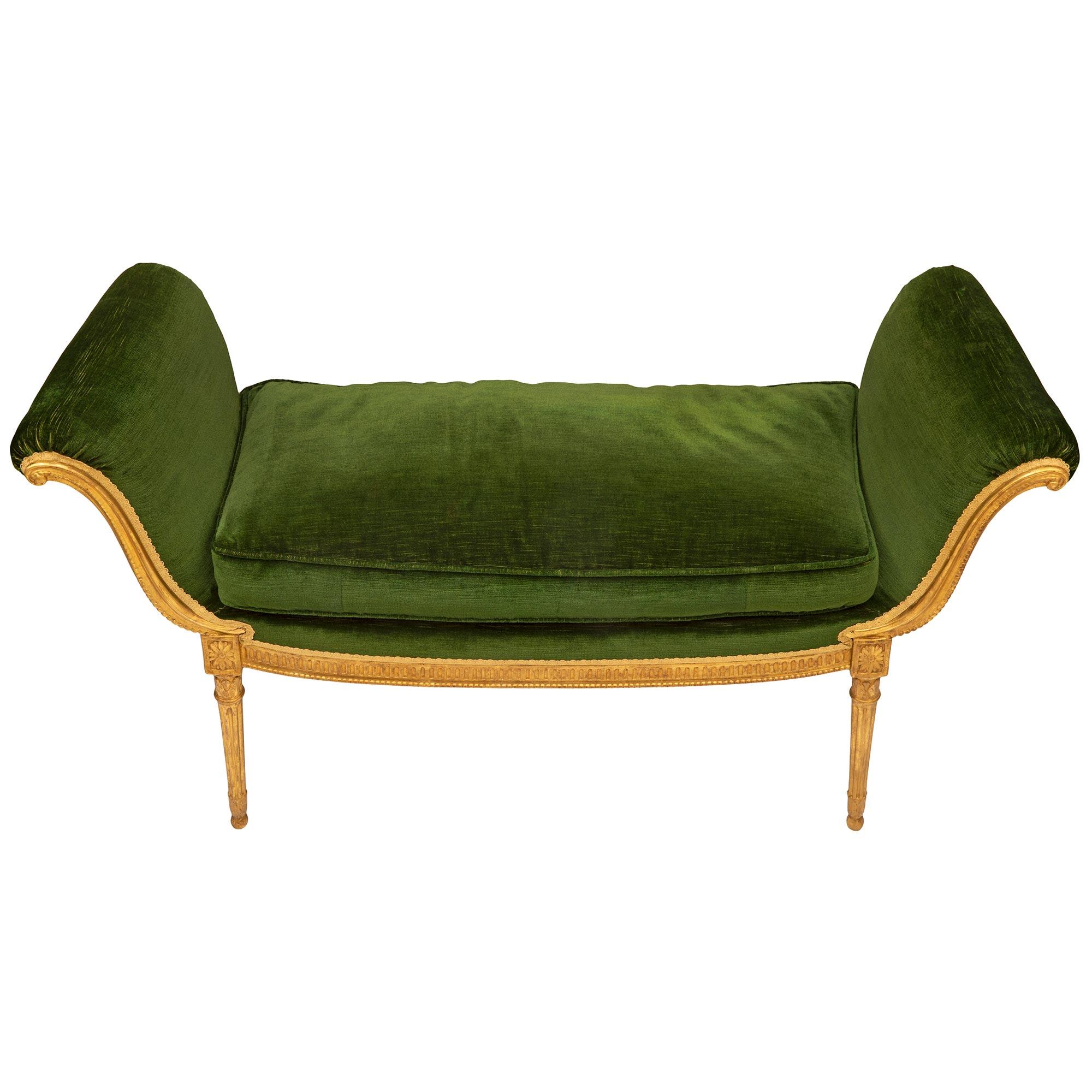 A most elegant French 19th century Louis XVI st. giltwood and green velvet bench. The bench is raised by slender circular tapered fluted legs with fine foliate and ball feet with lovely mottled top caps below block reserves. The frieze displays
