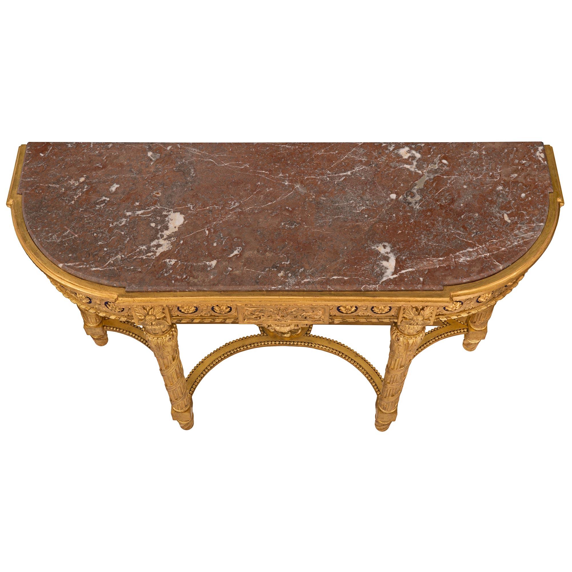 Magnifique et unique console en bois doré et marbre avec miroir, d'époque Louis XVI et Belle Époque. La console est surélevée par d'élégants pieds cannelés en spirale sous de saisissants pieds cannelés circulaires légèrement effilés avec un