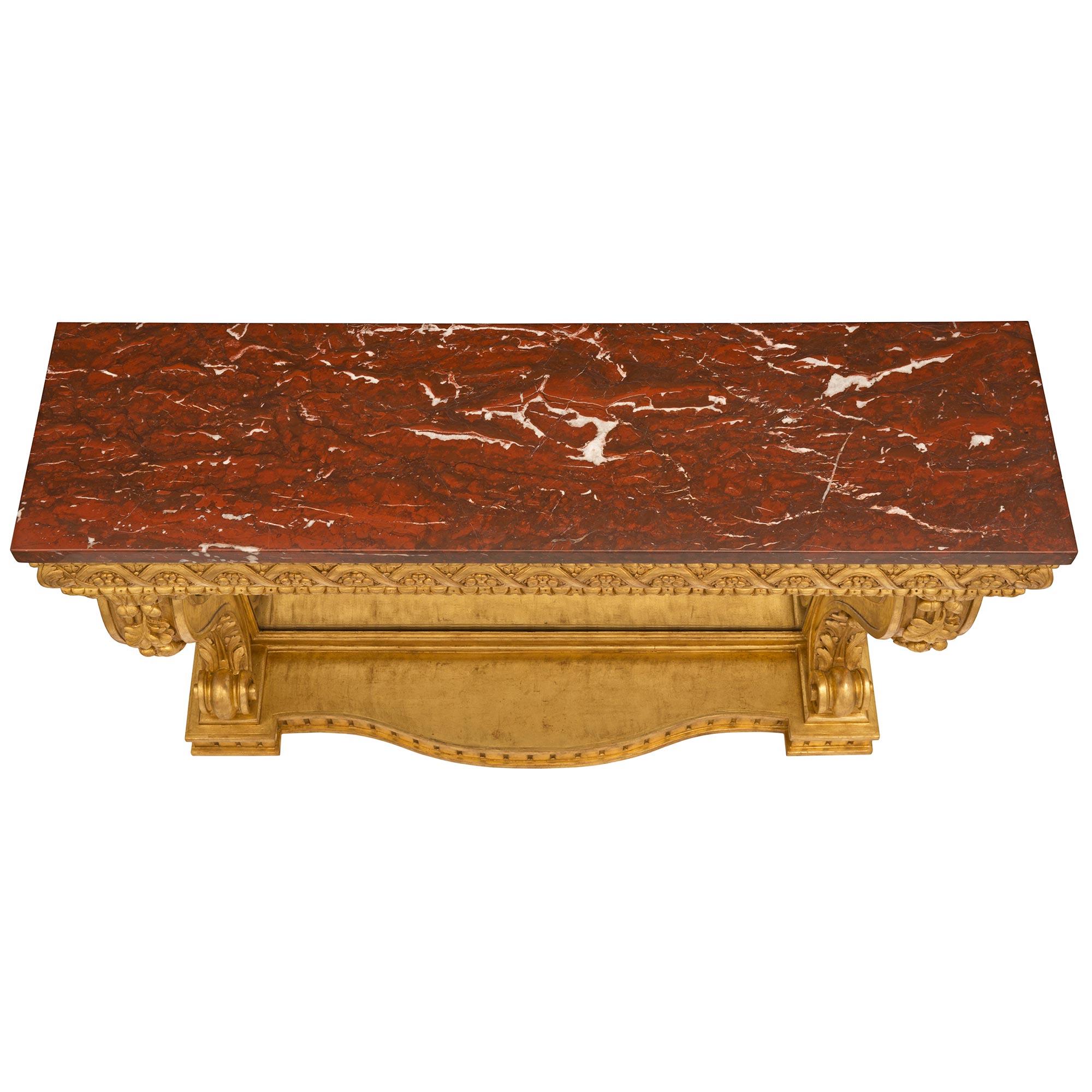 A stunning and extremely elegant French 19th century Louis XVI st. Belle Époque period giltwood and Rouge Griotte marble console. The uniquely scaled freestanding console is raised by a superb bottom tier with a beautiful scalloped movement and fine