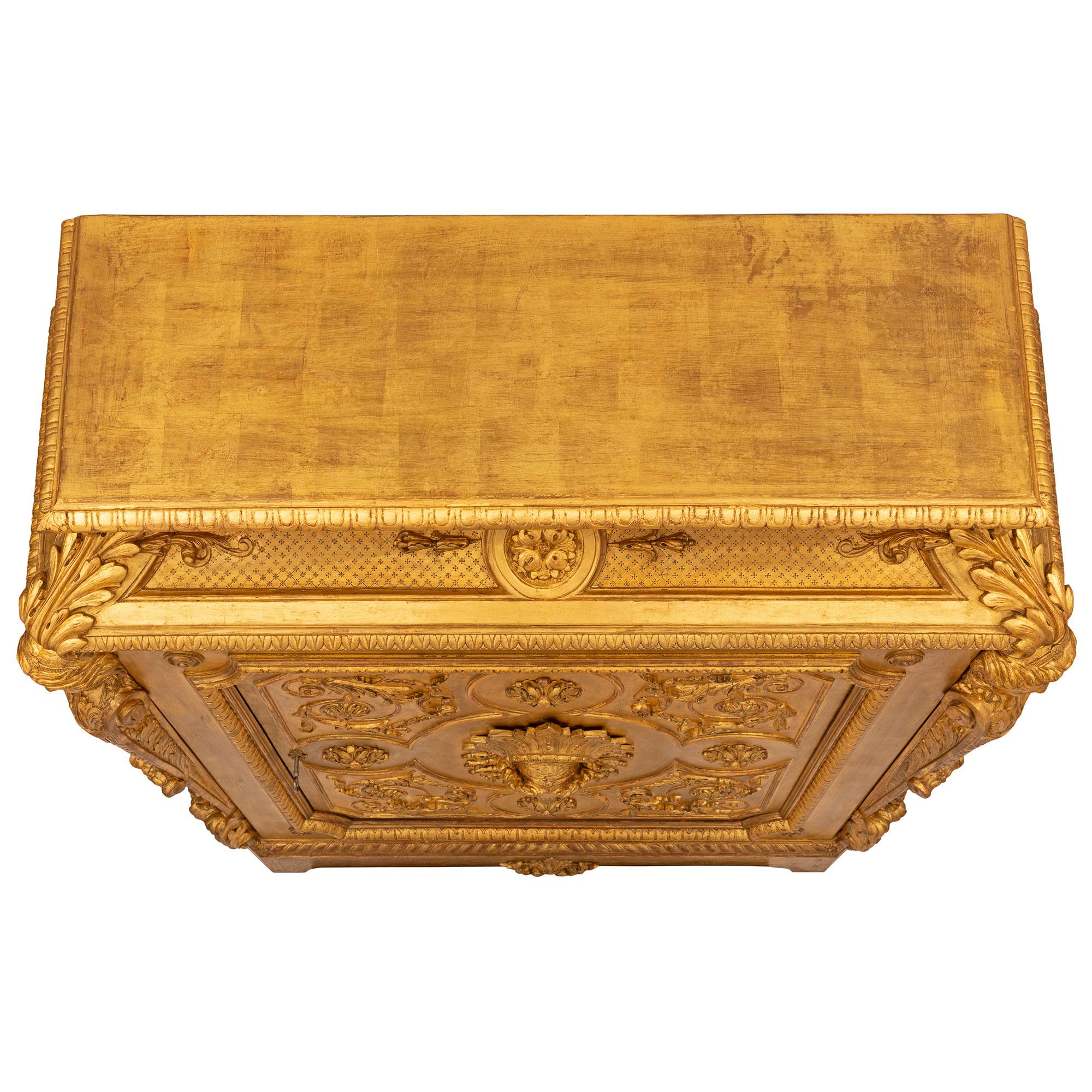 A stunning and extremely decorative French 19th century Louis XVI st. giltwood cabinet. The cabinet is raised by fine block supports with elegant fillets and a central carved foliate reserve. The single door displays an exceptional intricately
