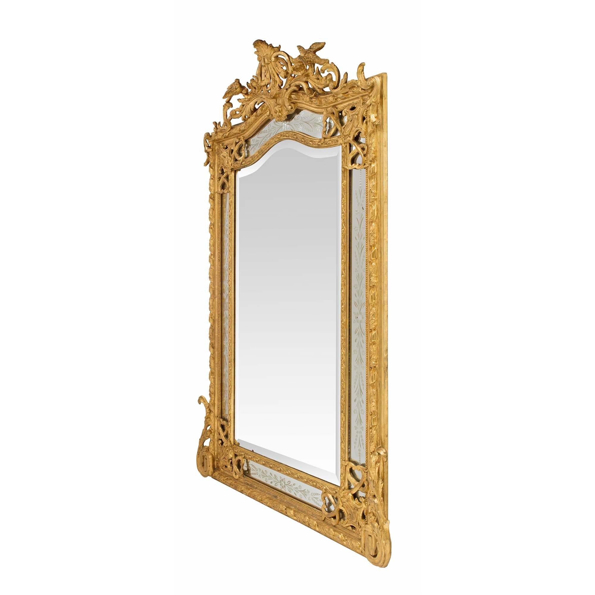 A beautiful French 19th century Louis XVI st. giltwood double framed mirror. The original central beveled mirror plate which follows the shape of the mirror is framed within a fine carved and beaded border. Leading out are the original and most