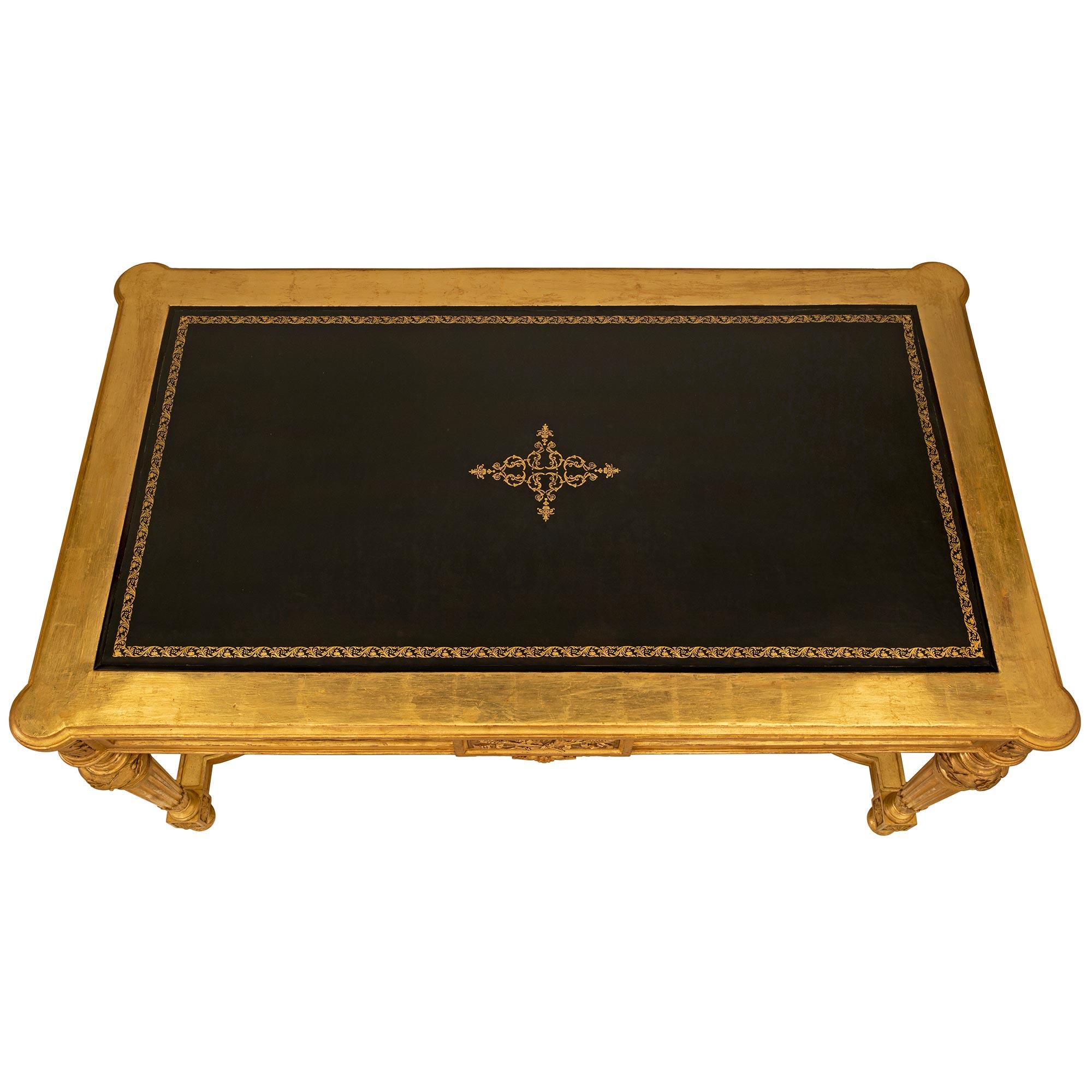 A striking and high quality French 19th century Louis XVI st. giltwood, ebonized fruitwood and leather center table. The rectangular table is raised by elegant circular fluted tapered legs with fine topie shaped feet and beautiful finely carved