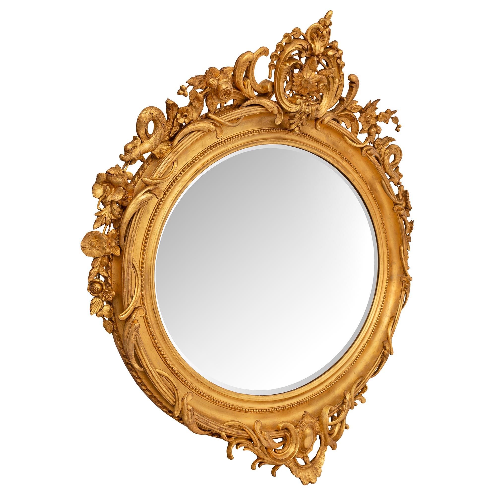 Ein auffälliger und beeindruckender französischer Vergoldungsspiegel im Stil Louis XVI des 19. Der großformatige, ovale Spiegel behält seine ursprüngliche, abgeschrägte Spiegelplatte, die in einen gesprenkelten Goldholzrahmen mit einem feinen,