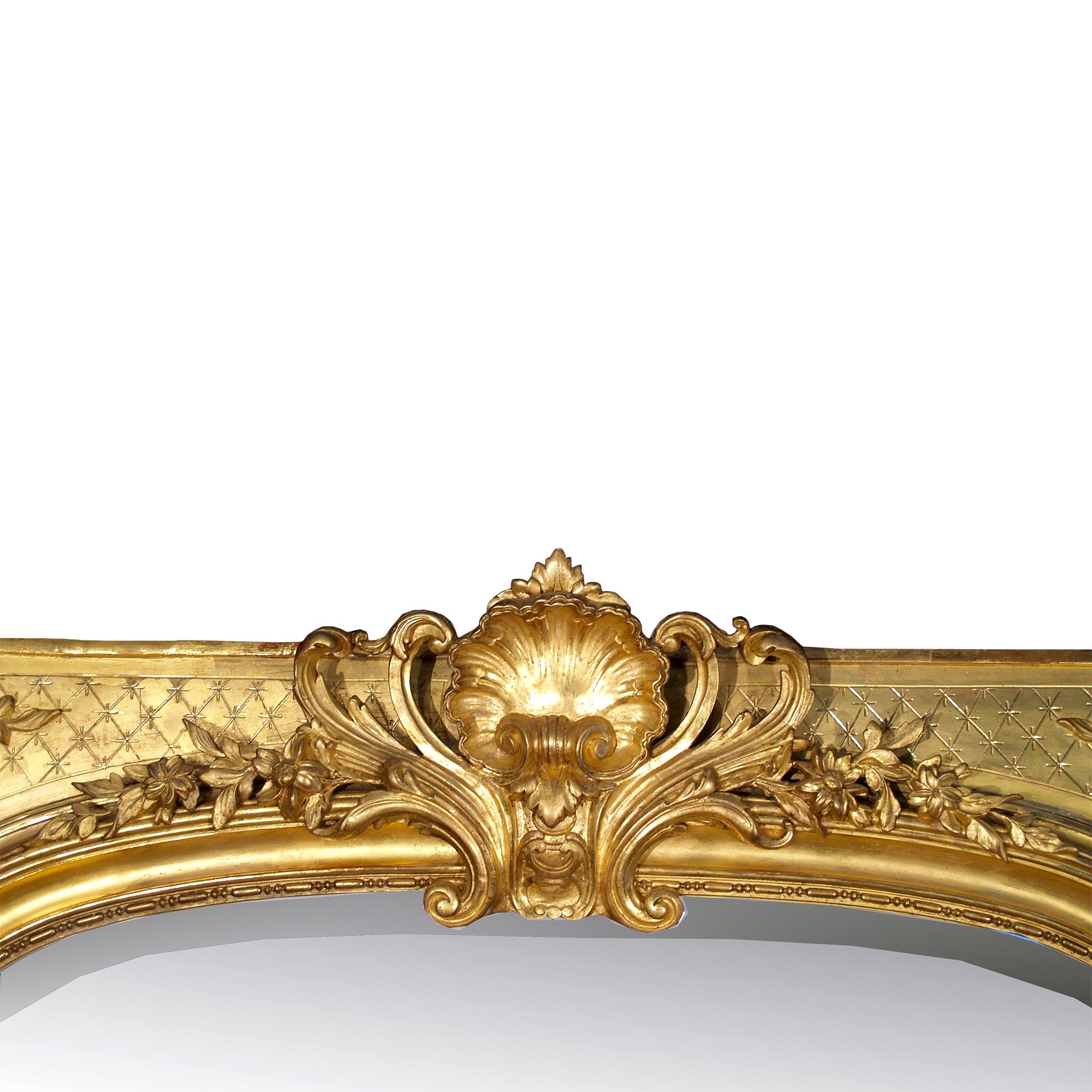 Un très joli miroir en bois doré de style Louis xvi du 19ème siècle avec sa plaque de miroir biseautée d'origine. Les côtés présentent une bordure moulée décorée de guirlandes de roses sculptées entrelacées. Au sommet se trouve une impressionnante