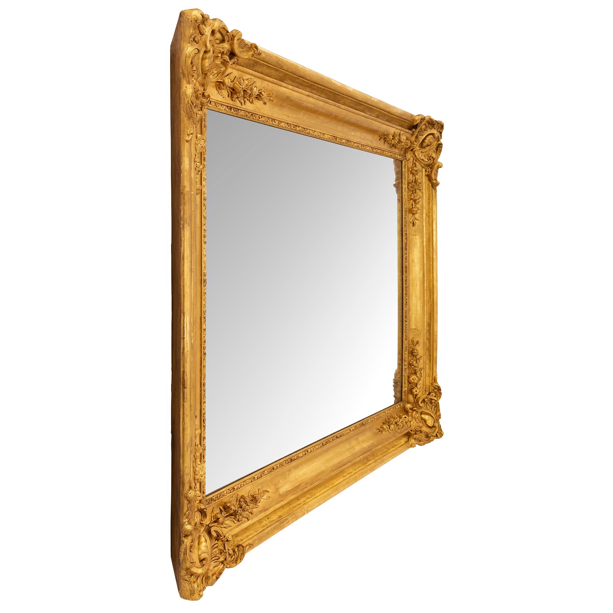 An impressive French 19th century Louis XVI st. giltwood mirror. The original mirror plate is set within a fine wrap around foliate and mottled frame. At each corner are beautiful extremely decorative foliate reserves with charming richly carved