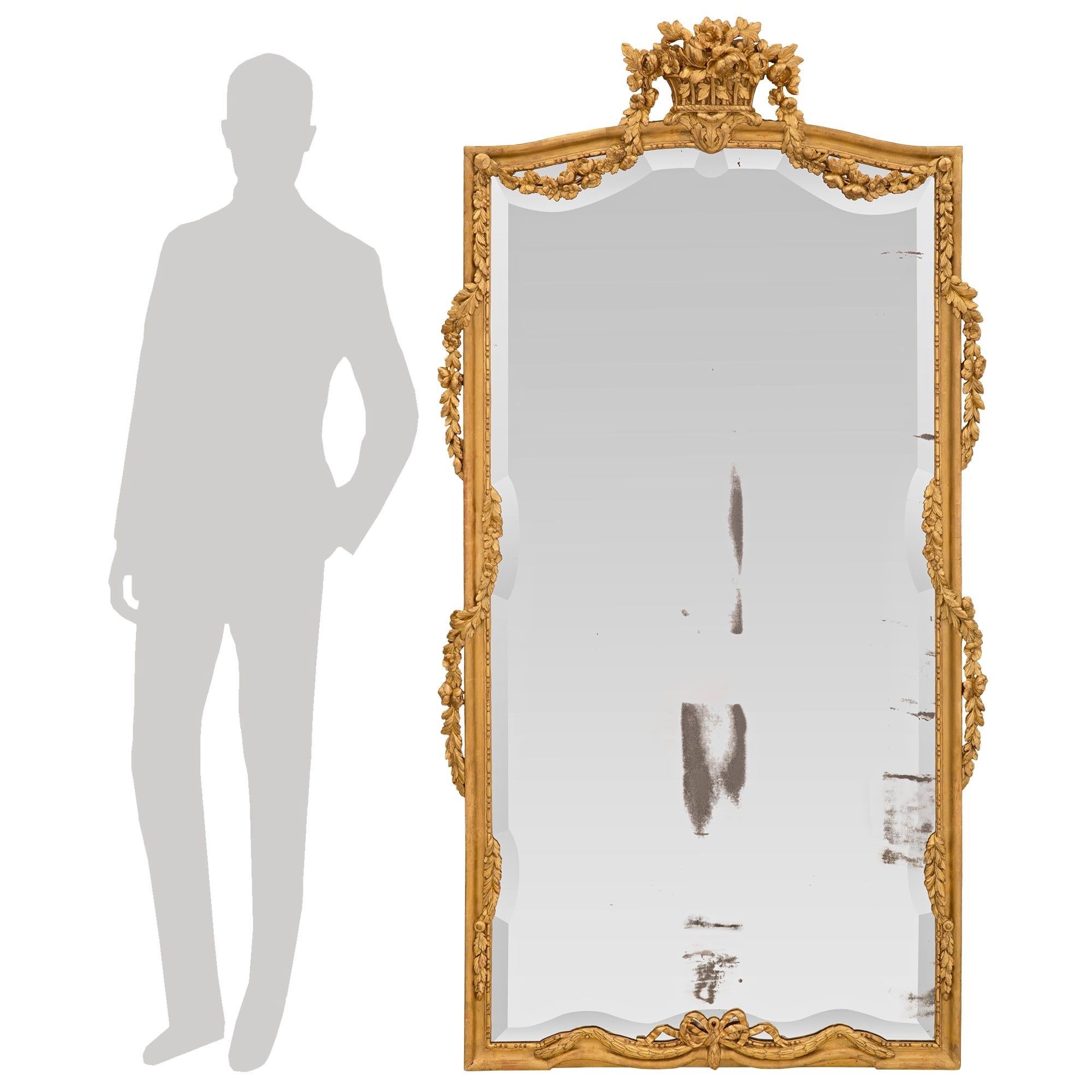A most elegant and unique French 19th century Louis XVI st. giltwood mirror. The mirror retains its original mirror plate with an exceptional and wonderfully executed beveled border following the beautiful shape of the giltwood frame. The frame