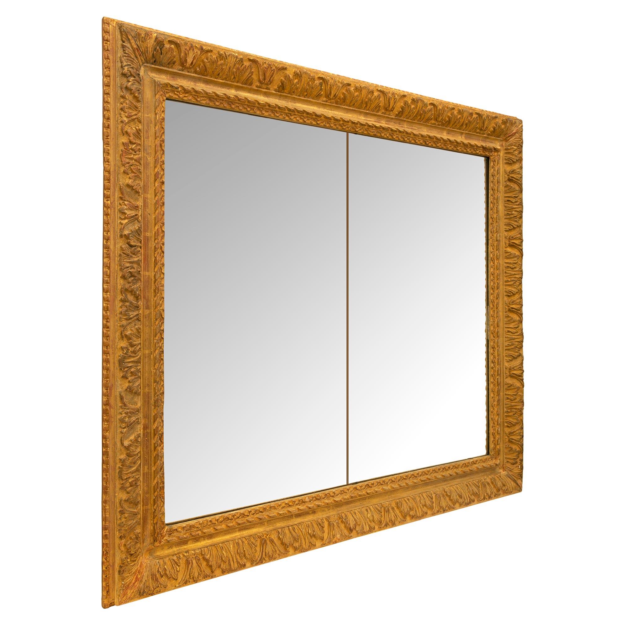 Un'attraente specchiera francese del XIX secolo in legno dorato di stile Luigi XVI. Lo specchio rettangolare conserva le lastre originali, inserite in una bella cornice in legno dorato screziato con un raffinato disegno a nastro ritorto e superbe