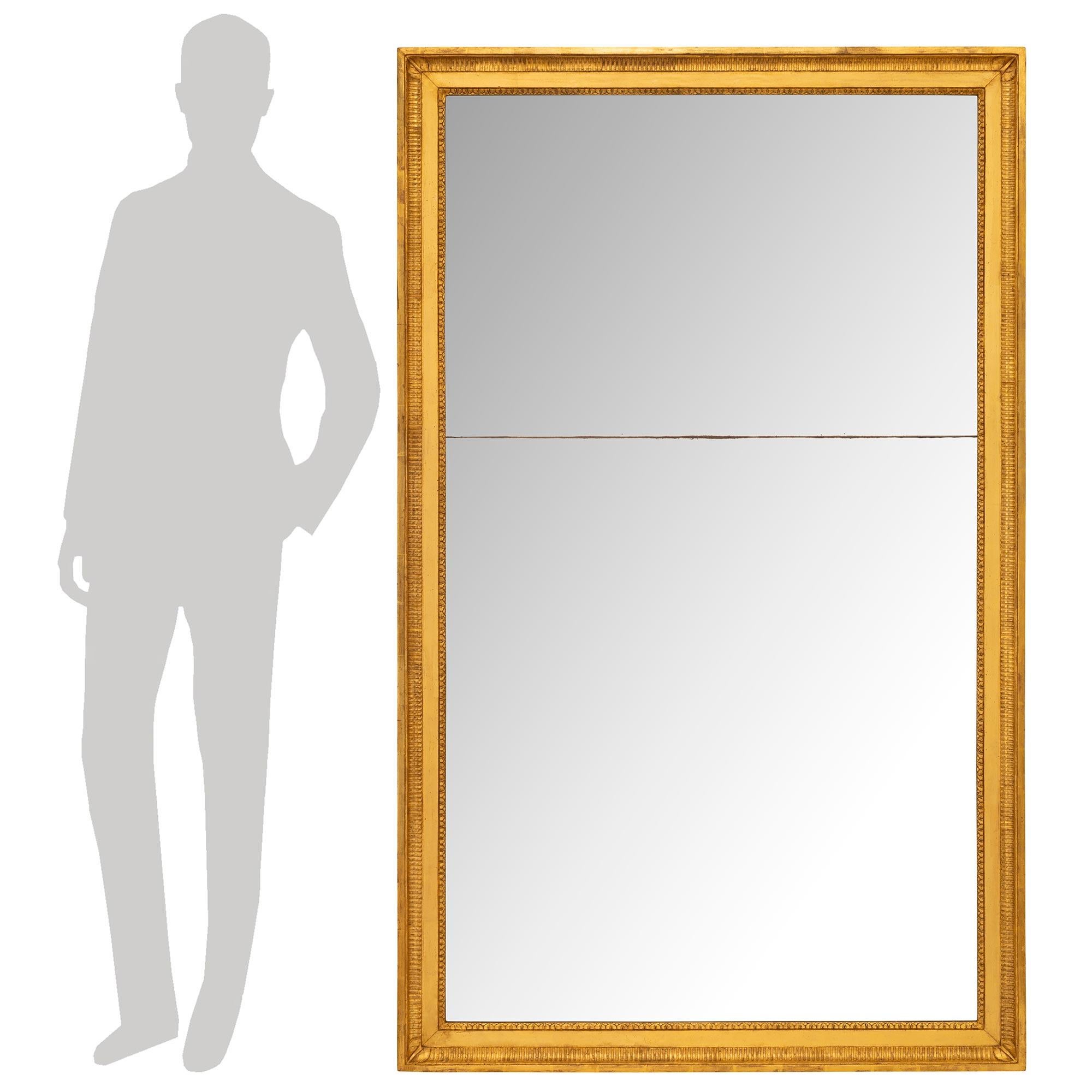 Grand miroir en bois doré de style Louis XVI du XIXe siècle, très décoratif. Cet impressionnant miroir rectangulaire est encadré dans un superbe cadre en bois doré tacheté. Le cadre présente une fine bande intérieure de Cœur-de-Rai, suivie d'une