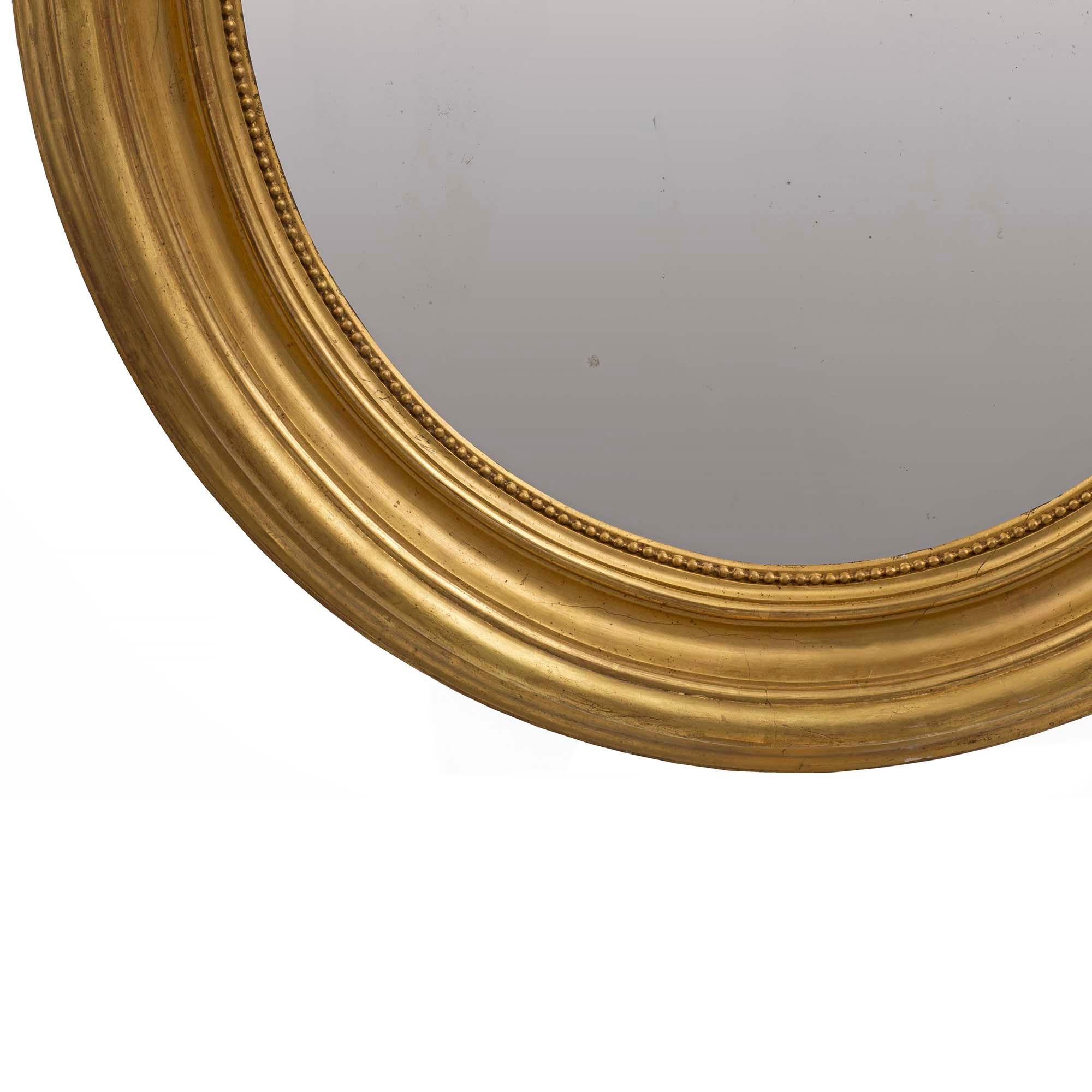 Français Miroir ovale français du 19ème siècle en bois doré de style Louis XVI en vente