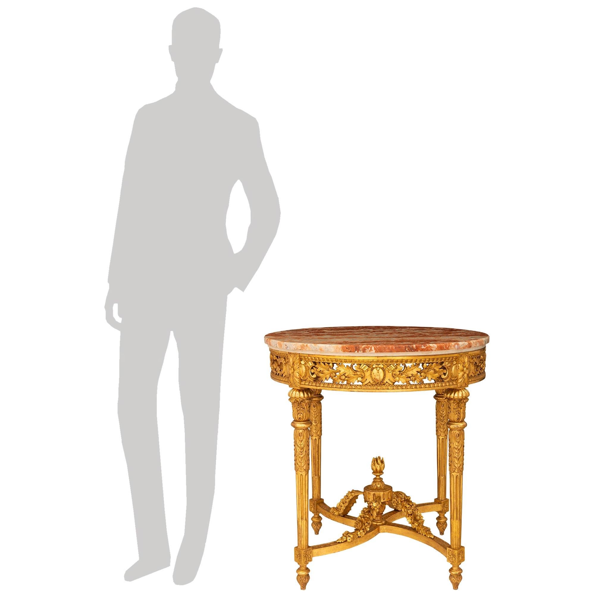 Table d'appoint impressionnante et de grande qualité en bois doré et marbre Rouge de Languedoc de style Louis XVI du XIXe siècle. Cette superbe table d'appoint circulaire repose sur quatre pieds fuselés et cannelés, ornés de feuilles d'acanthe