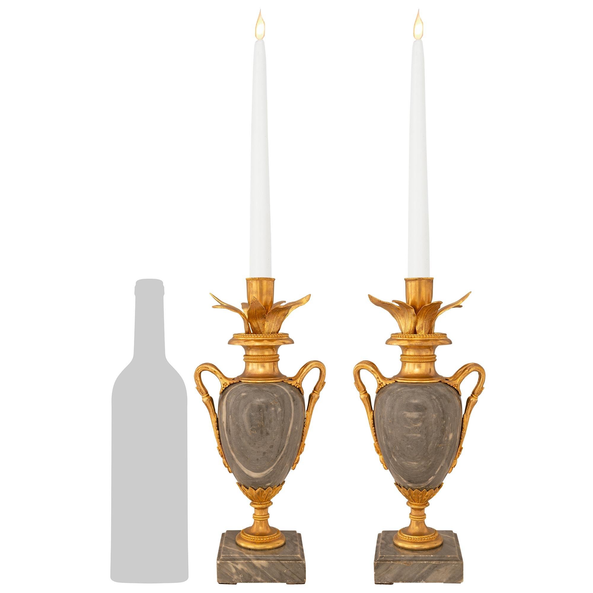 Una bella coppia di candelieri francesi del XIX secolo in marmo e ormolu di St. Gris St. Anne. Ogni splendida candela a forma di vaso è sollevata da una base quadrata a gradini in marmo con sopra una base circolare in Ormolu decorata con bande di
