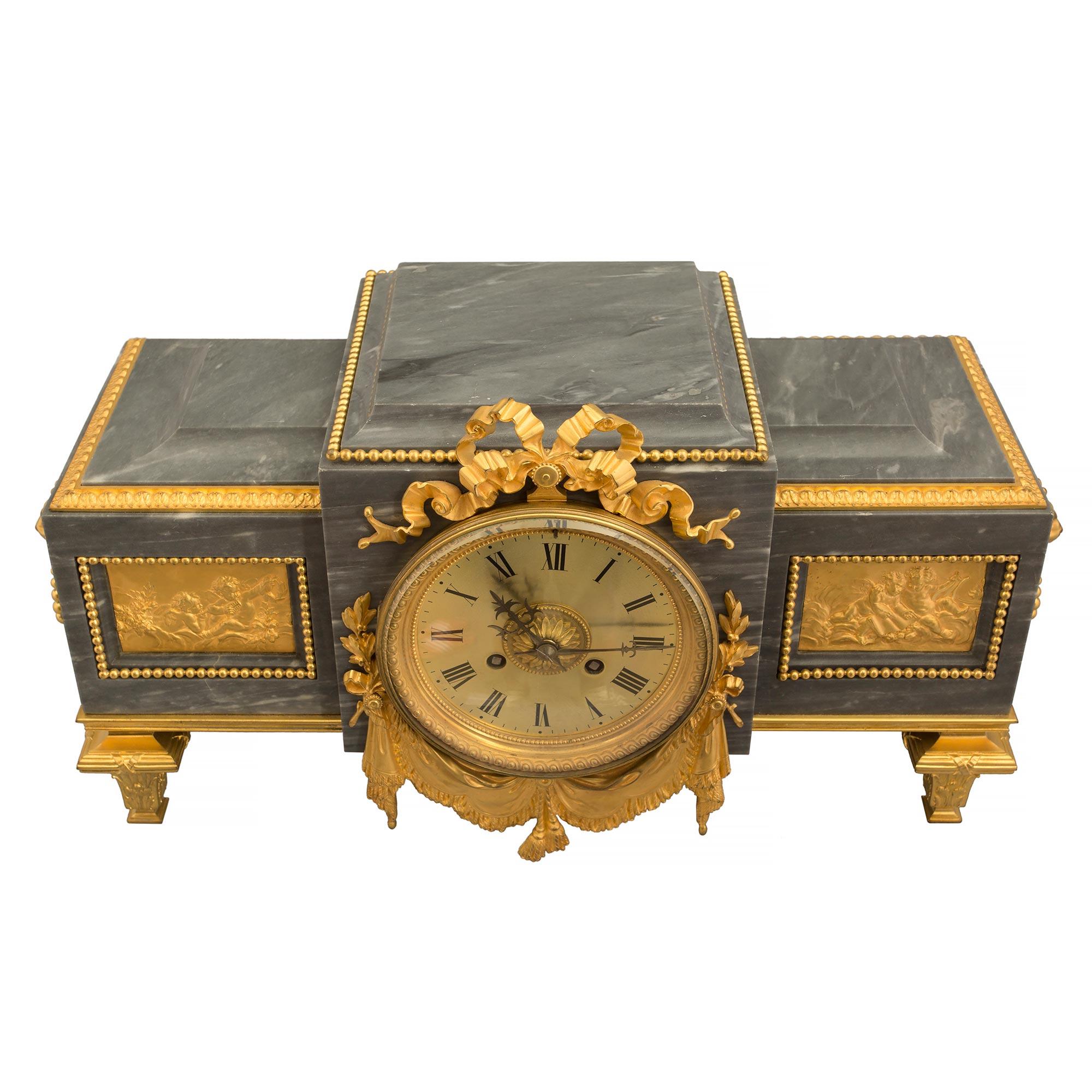 Elégante pendule à piédestal en marbre et bronze doré de style Louis XVI du XIXe siècle. L'horloge à piédestal de forme rectangulaire est surélevée par des pieds en forme de topie en bronze doré, sous un bandeau tacheté. Le centre en saillie