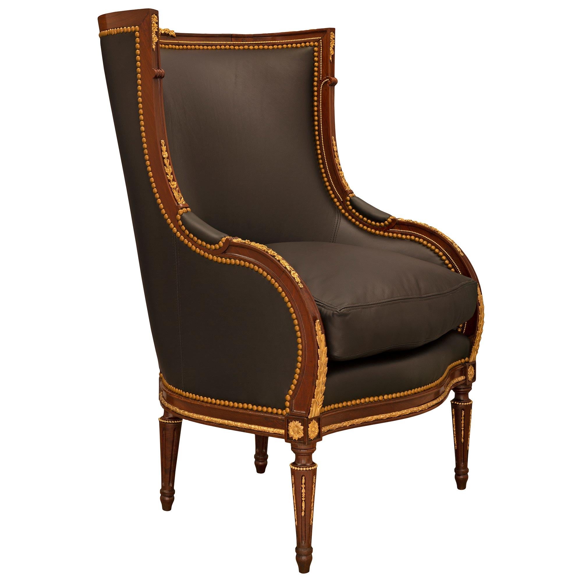 Ein auffallender und sehr eleganter französischer Louis XVI-Sessel aus Mahagoni und Ormolu aus dem 19. Der Stuhl wird von feinen kreisförmigen kannelierten konischen Beinen mit topie-förmigen Füßen, schönen eingefügten blattförmigen Ormolu