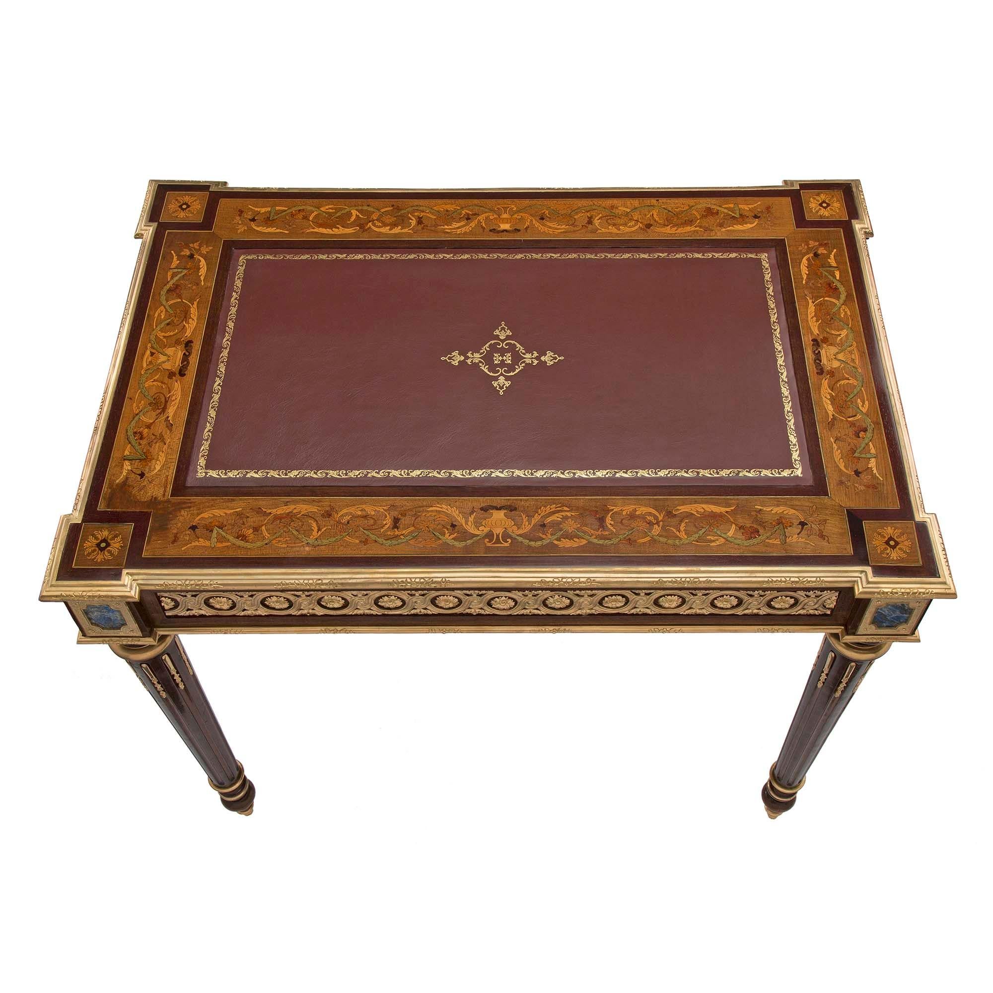 A superb and unique French 19th century Louis XVI st. mahogany and ormolu desk. The desk is raised on tapered fluted legs with ormolu chandelles and topie feet with ormolu sabots. At the impressive apron is a single drawer which has a secret