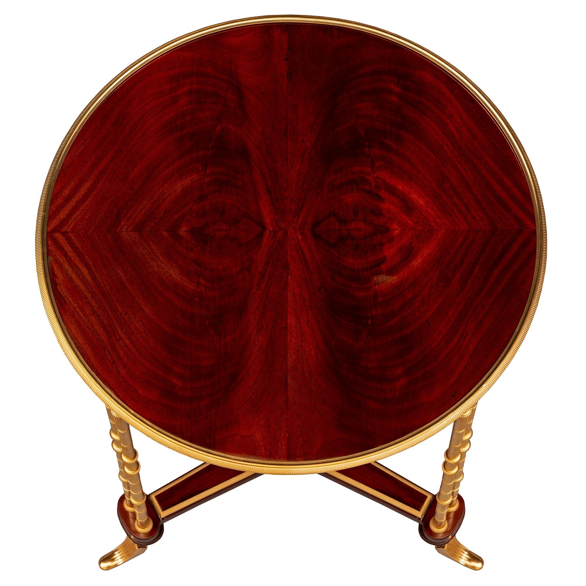 A stunning and extremely decorative French 19th century Louis XVI st. Mahogany and ormolu side table, after a model by Adam Weisweiler. The circular table is raised by three elegant and most unique double bamboo designed legs below curved feet